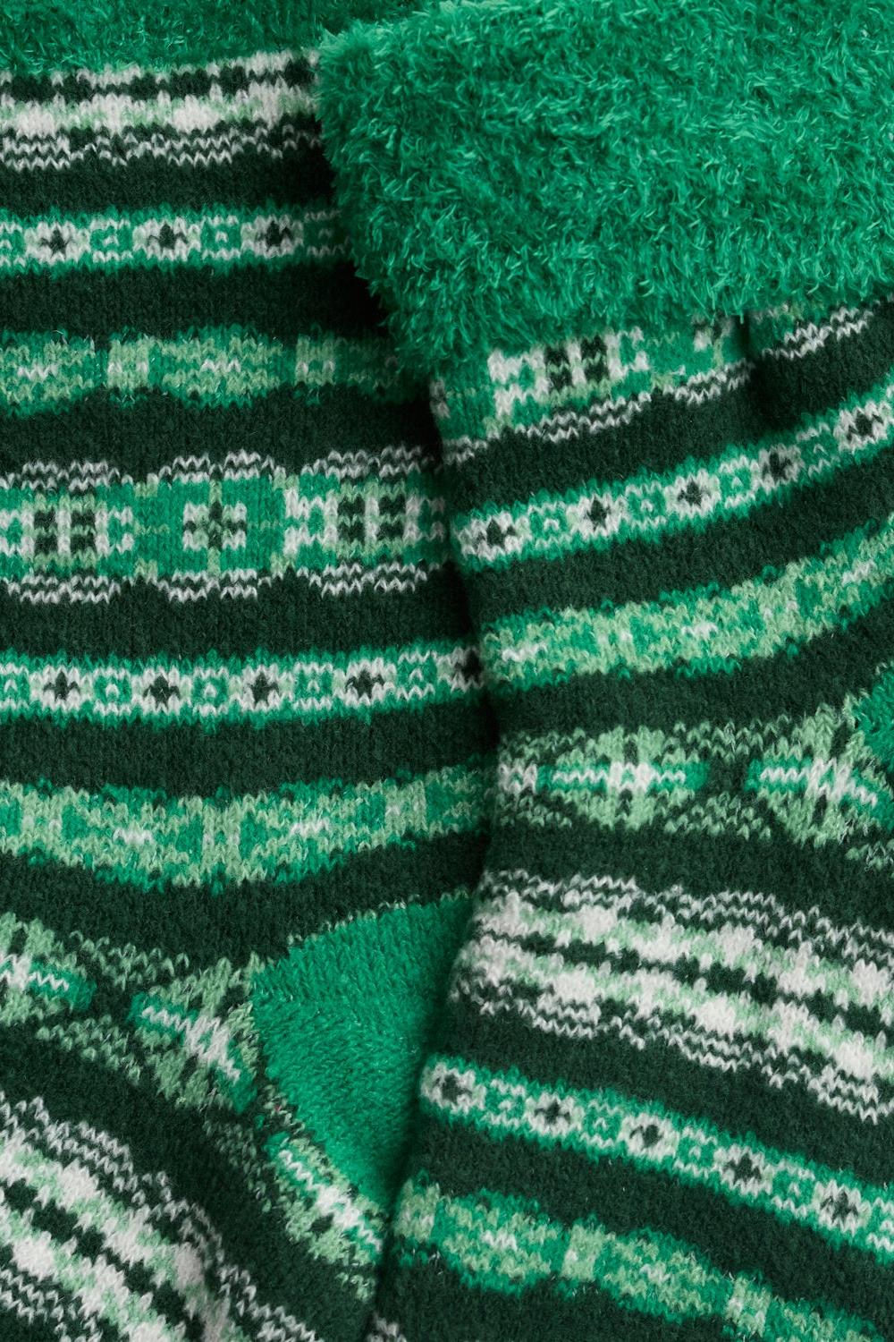 Close-up of Seasalt Cornwall green patterned cosy slipper socks made from soft fabric.