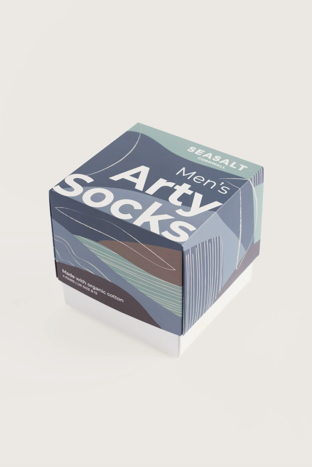 A box of Arty Men's Socks in the 'Seasalt' scent, featuring a modern geometric design in navy, slate blue, and white on a light beige background.
