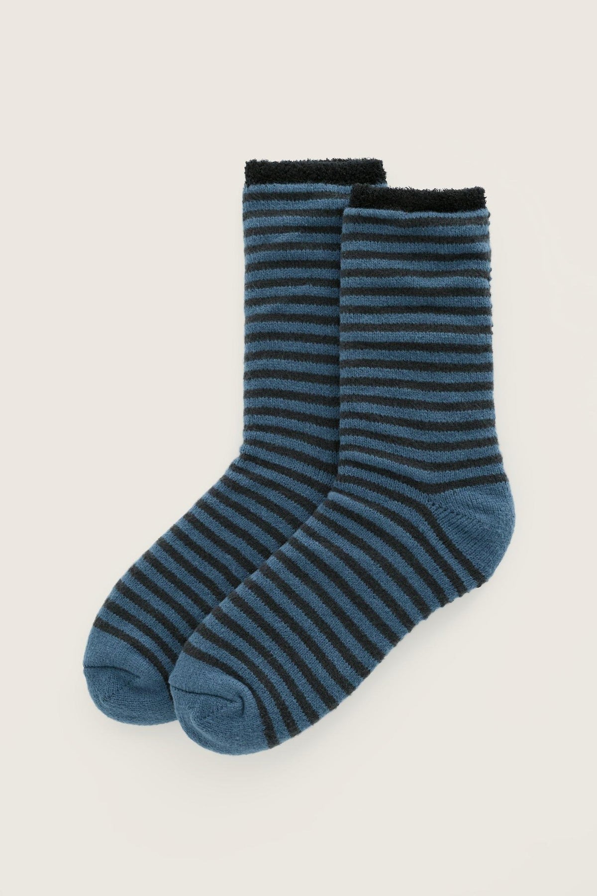 A pair of men's Seasalt Cornwall blue striped fluffy cosy socks isolated on a neutral background.