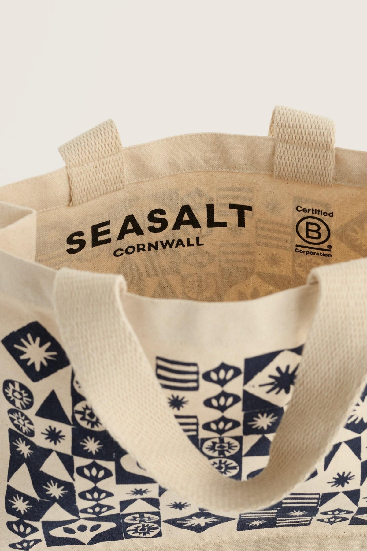 Open interior of a cream-colored organic cotton Seasalt Cornwall canvas bag with a dark blue geometric pattern.
