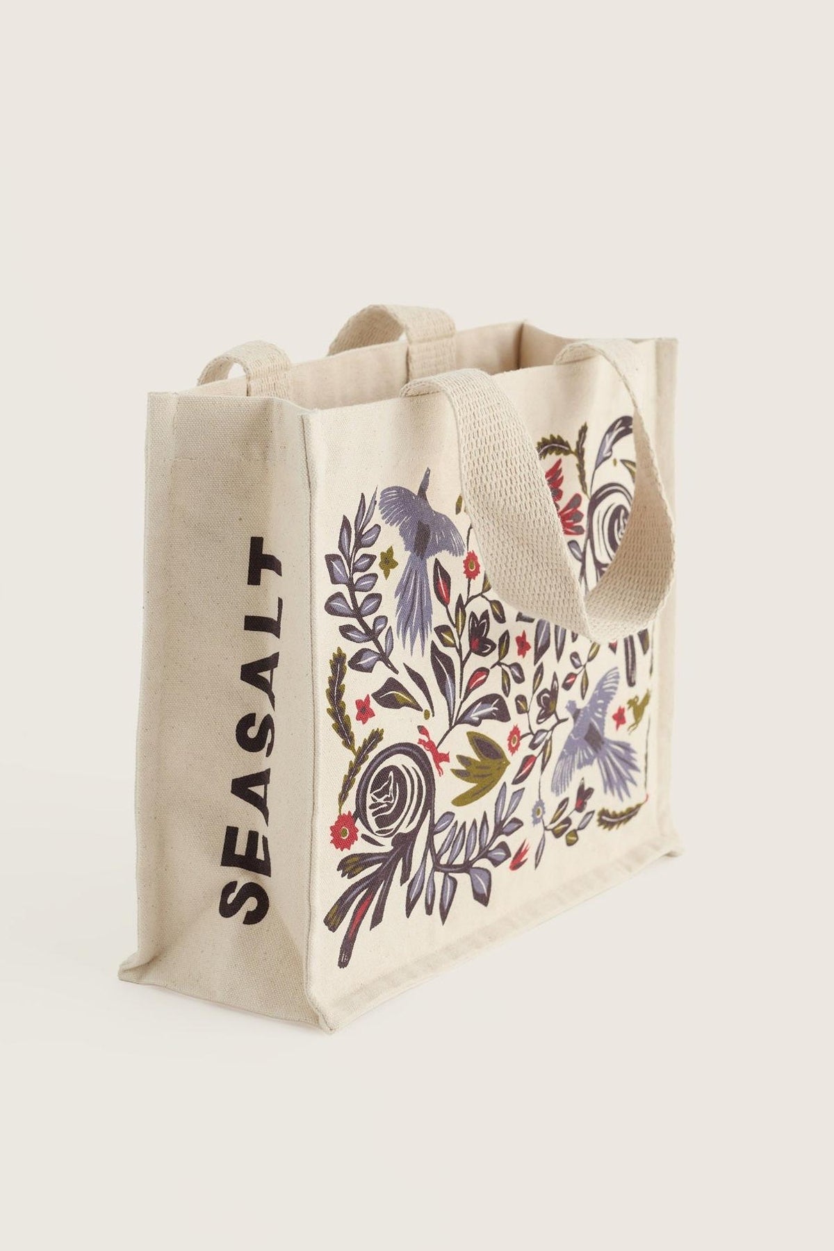 A Seasalt Cornwall organic cotton canvas shopping bag featuring a colorful floral and bird pattern on a neutral background.