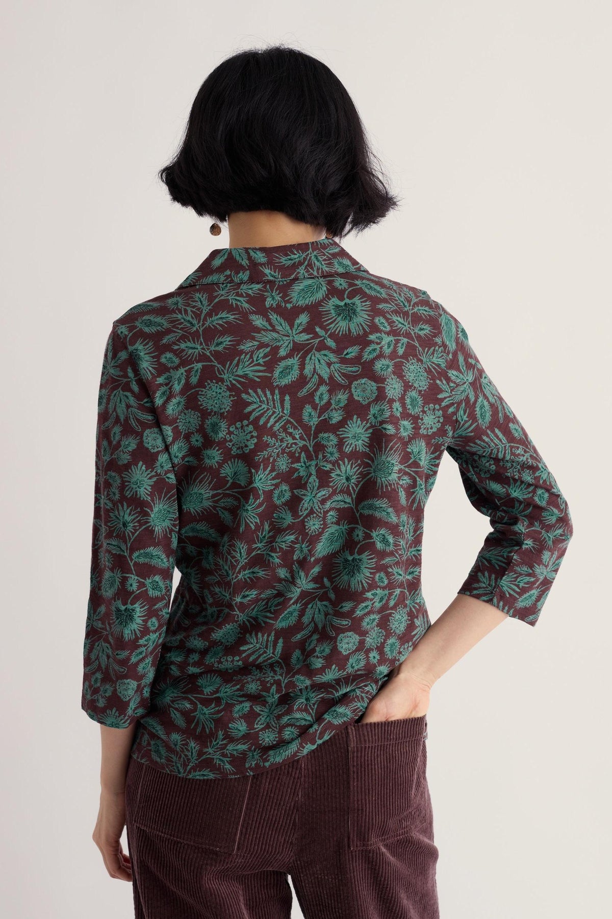 Woman wearing a brown and blue floral organic cotton long sleeve shirt from Seasalt Cornwall seen from behind.