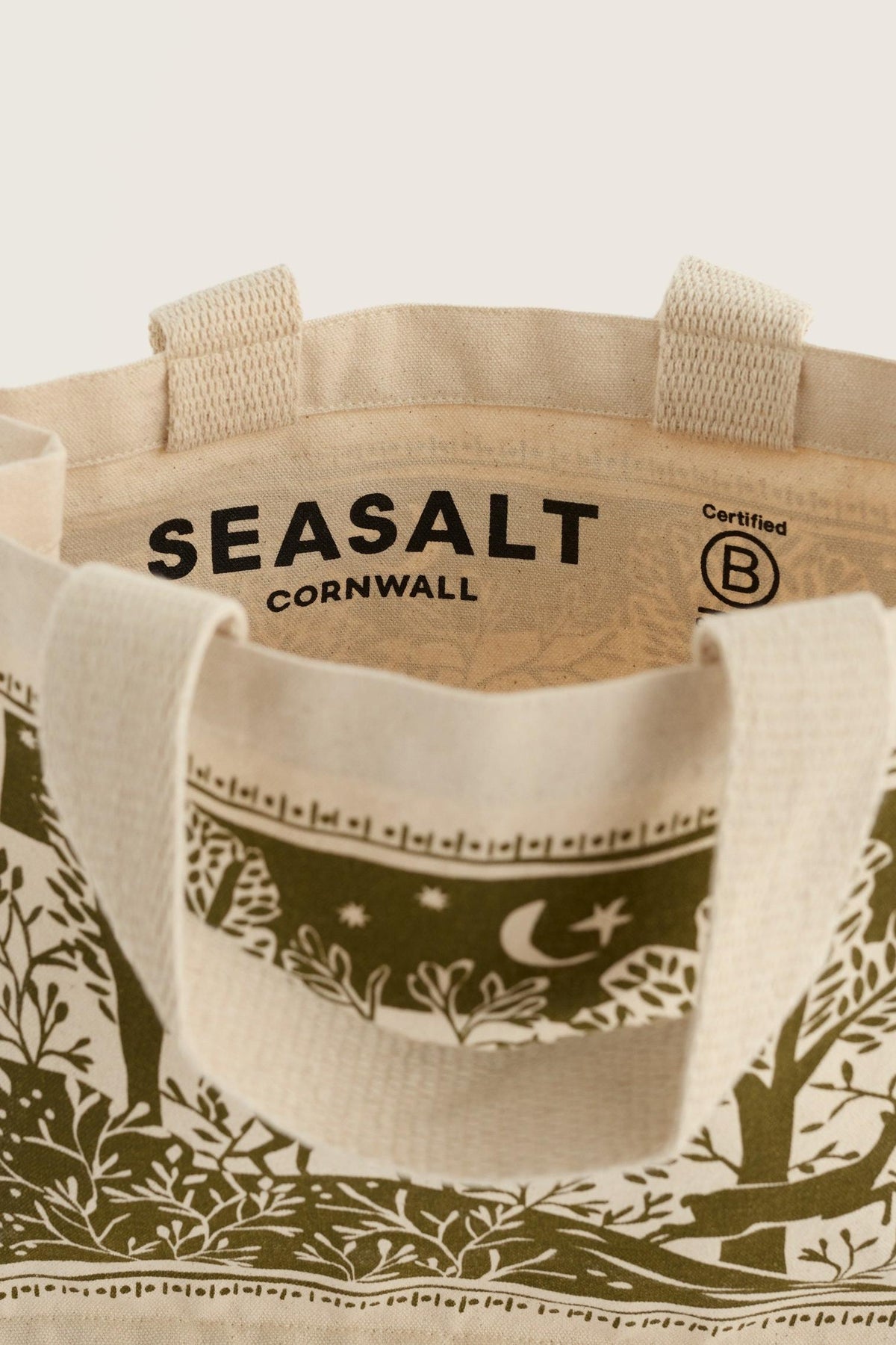Open view of a Seasalt Cornwall organic cotton shopping bag with a festive green and white nature-inspired print.