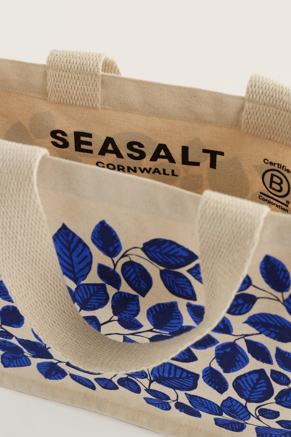 A Seasalt Cornwall organic cotton shopping bag with a blue leaf pattern and Certified B Corporation logo.