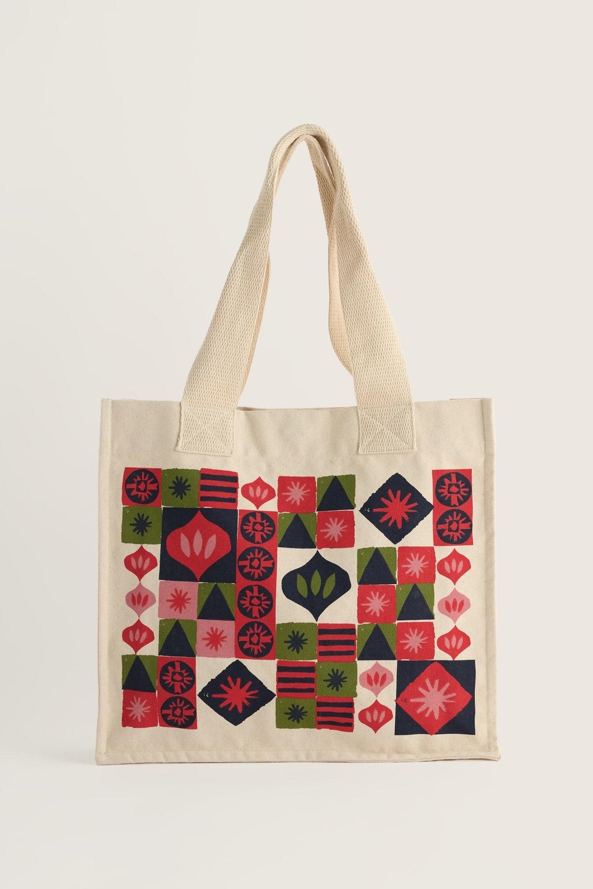 Seasalt Cornwall patterned canvas tote bag featuring geometric festive shapes against a light background.