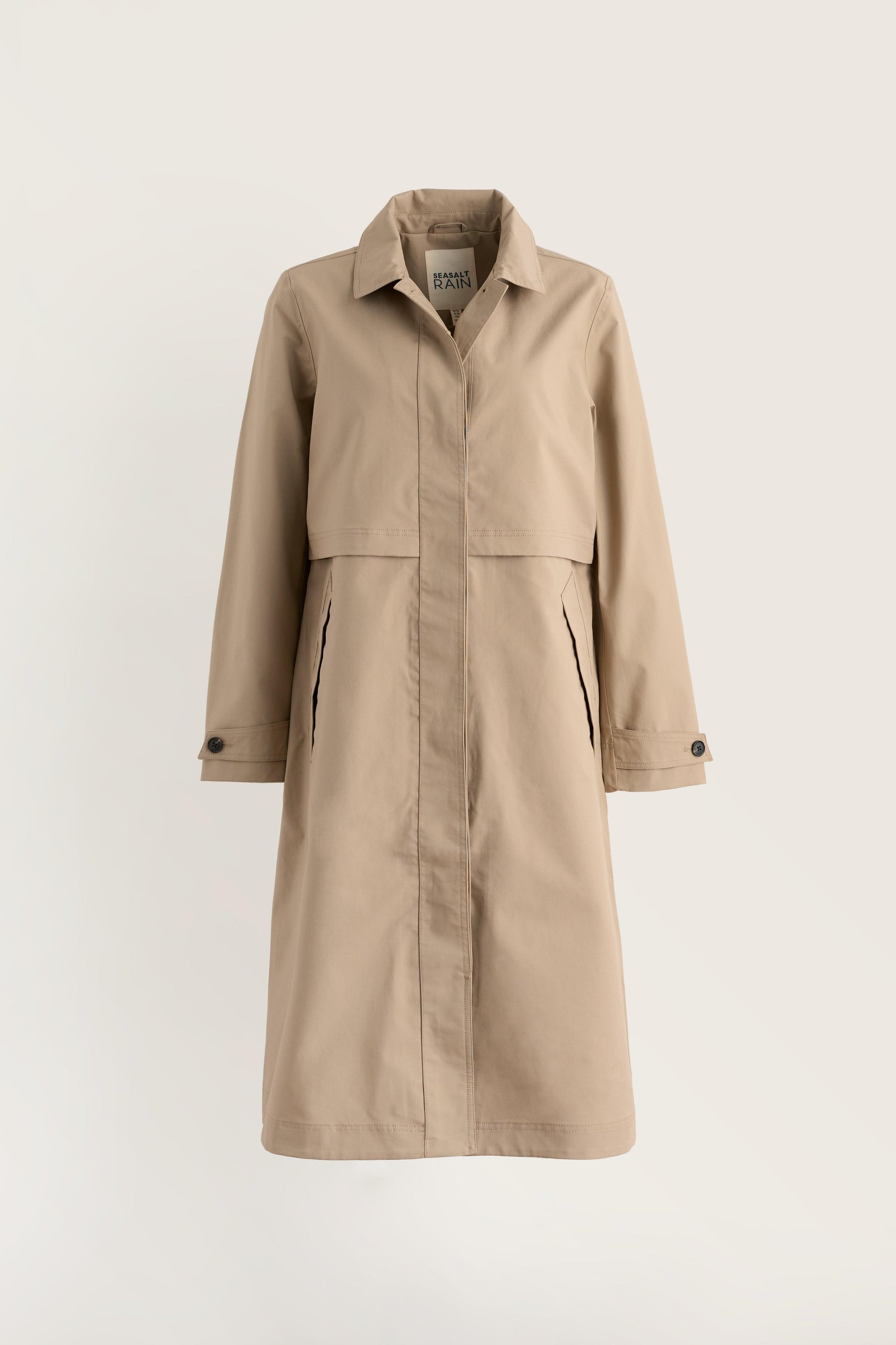 A beige trench coat with a pointed collar, front button closure, and side pockets, displayed on a clean, light off-white background.