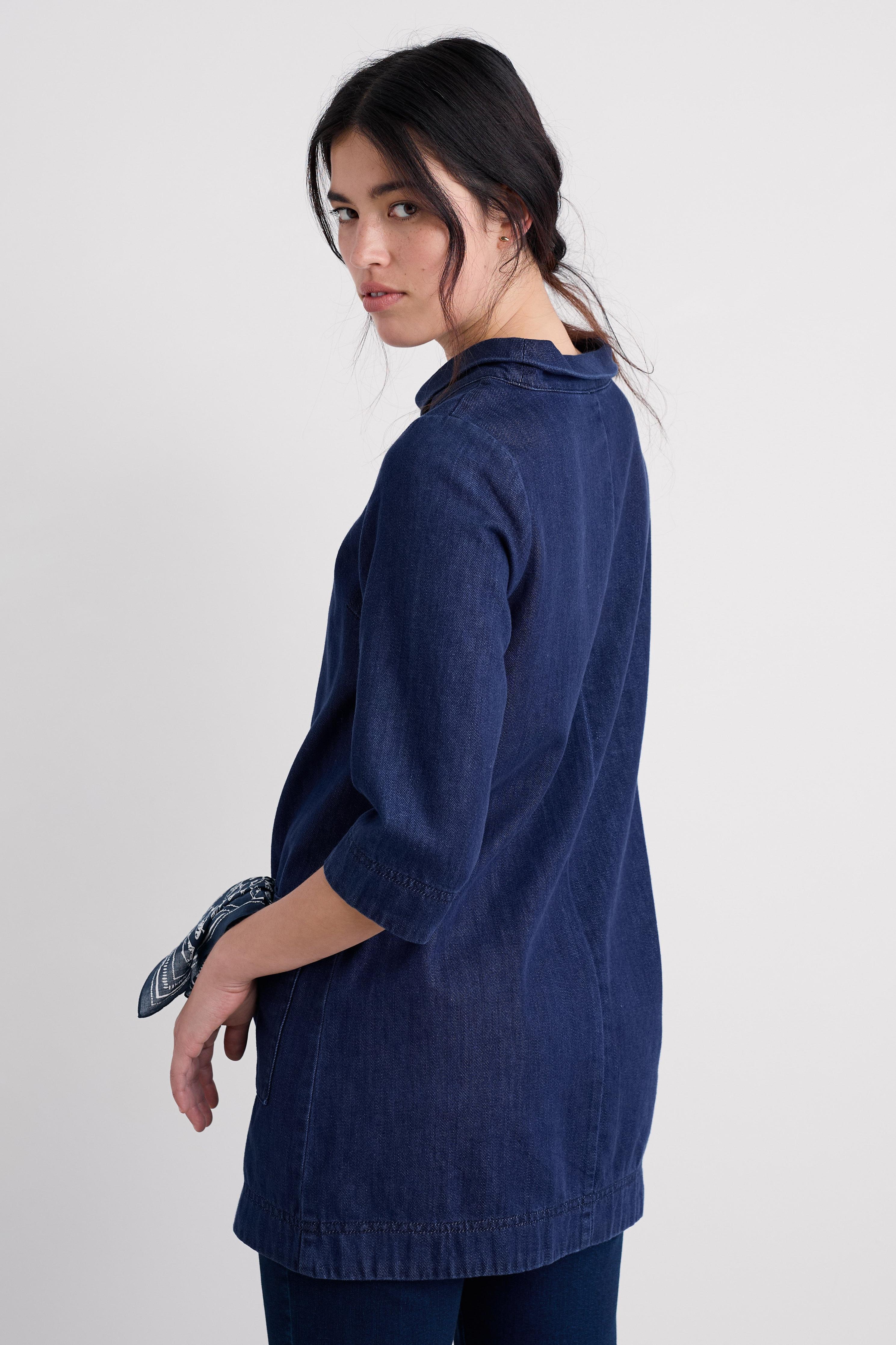 Woman wearing a blue organic cotton tunic against a white background