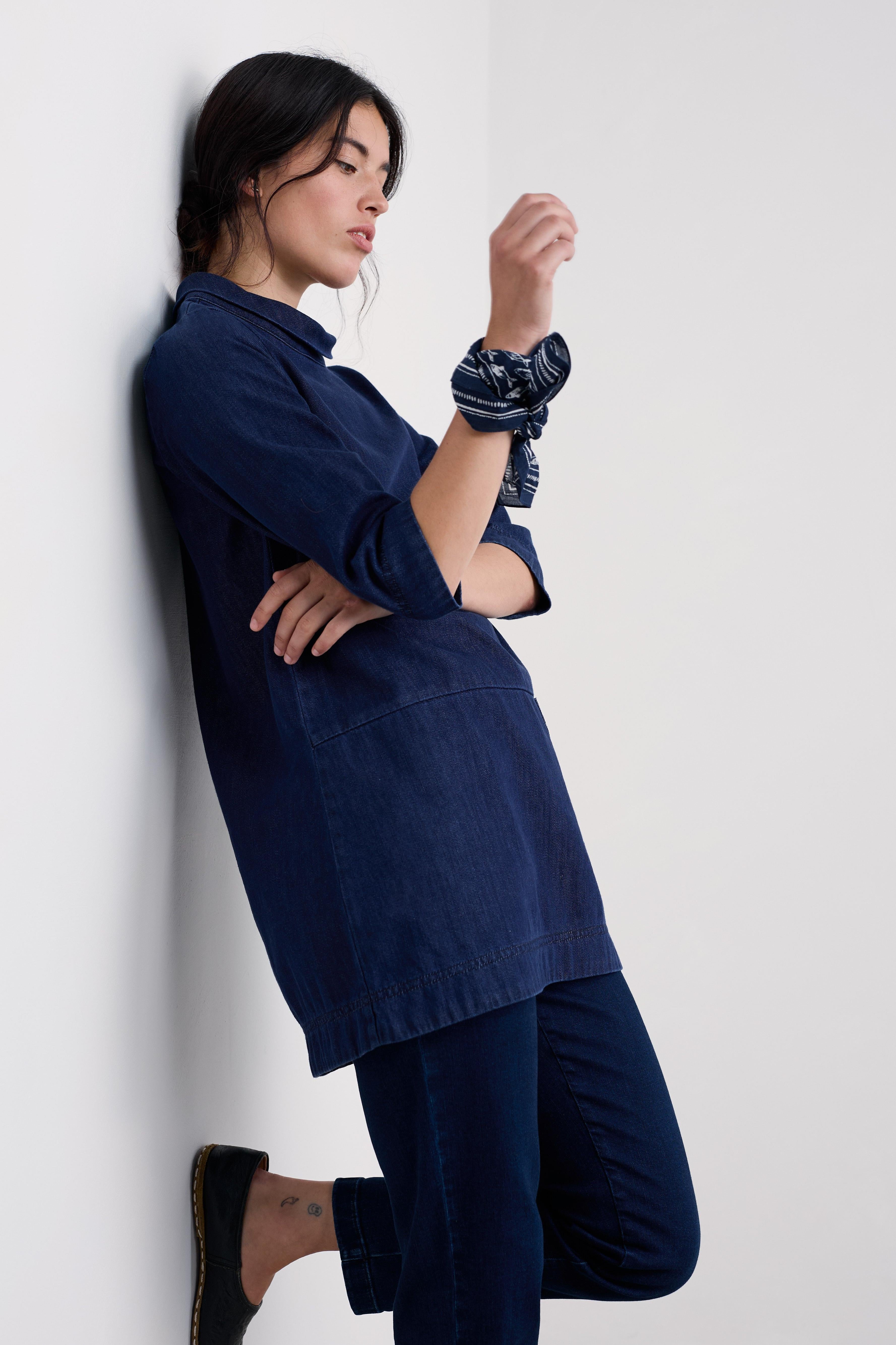 Person wearing a navy blue shirt and pants against a white background