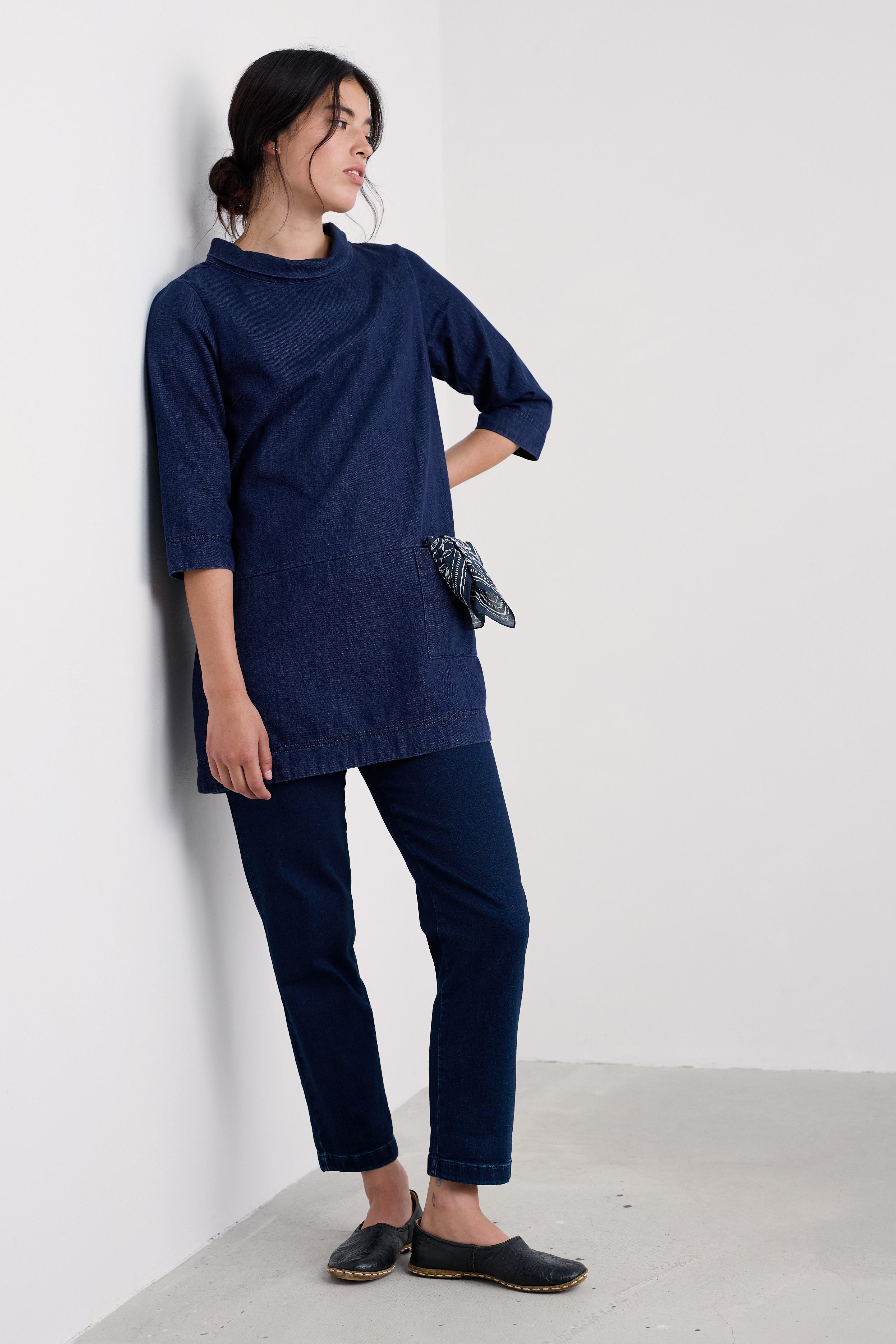 Woman wearing a navy organic cotton tunic against a white background