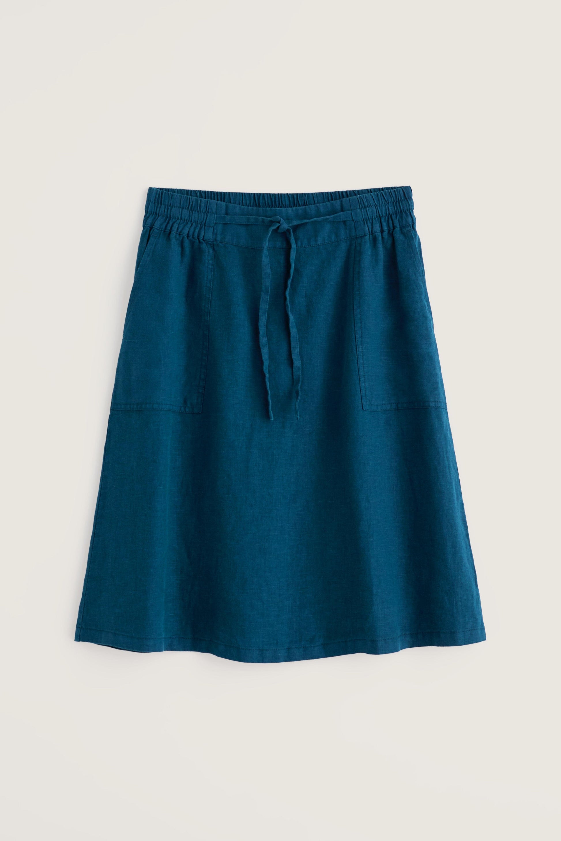 Blue linen skirt with a tie waist on a light beige background