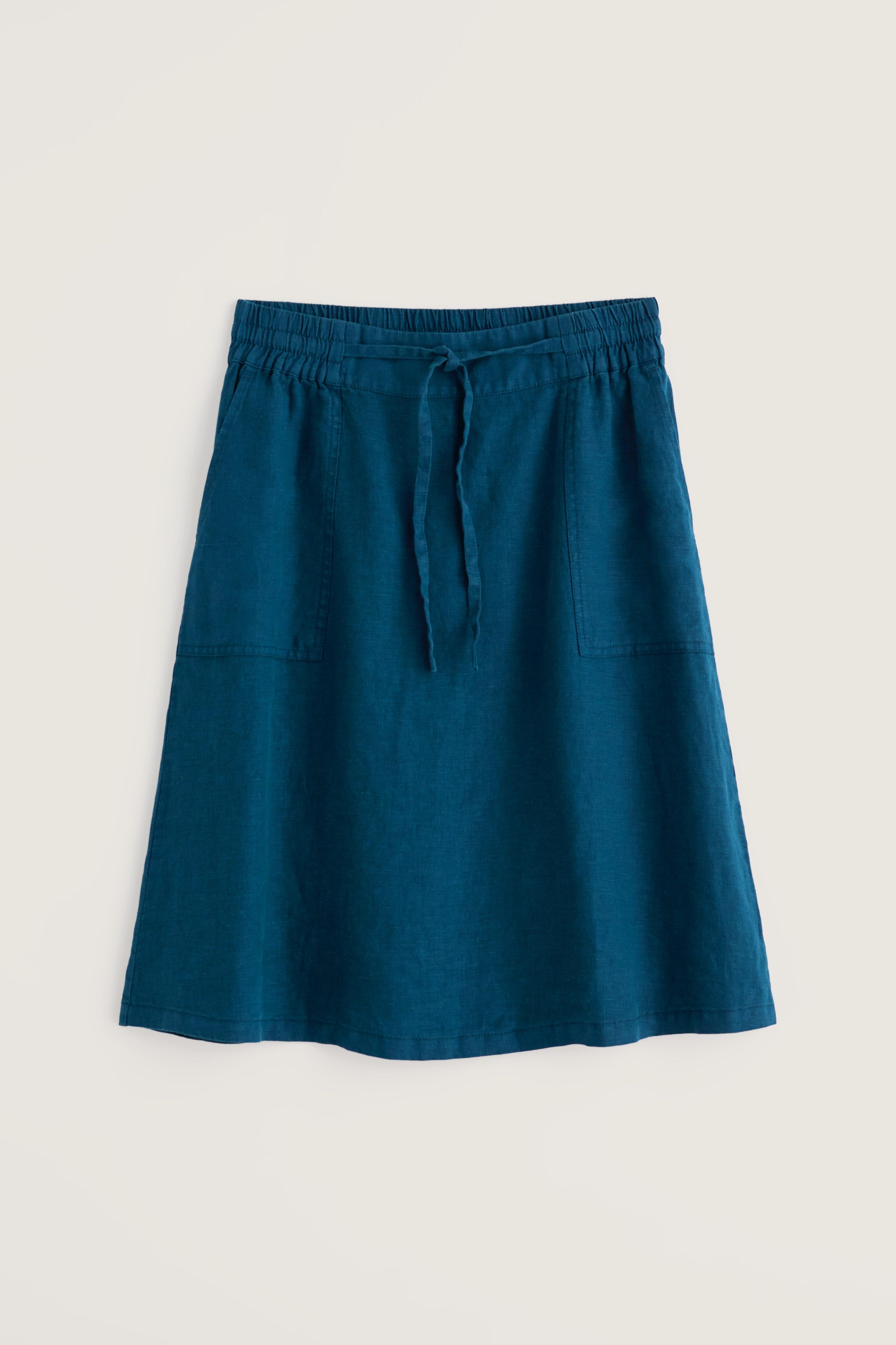 Blue linen skirt with a tie waist on a light beige background