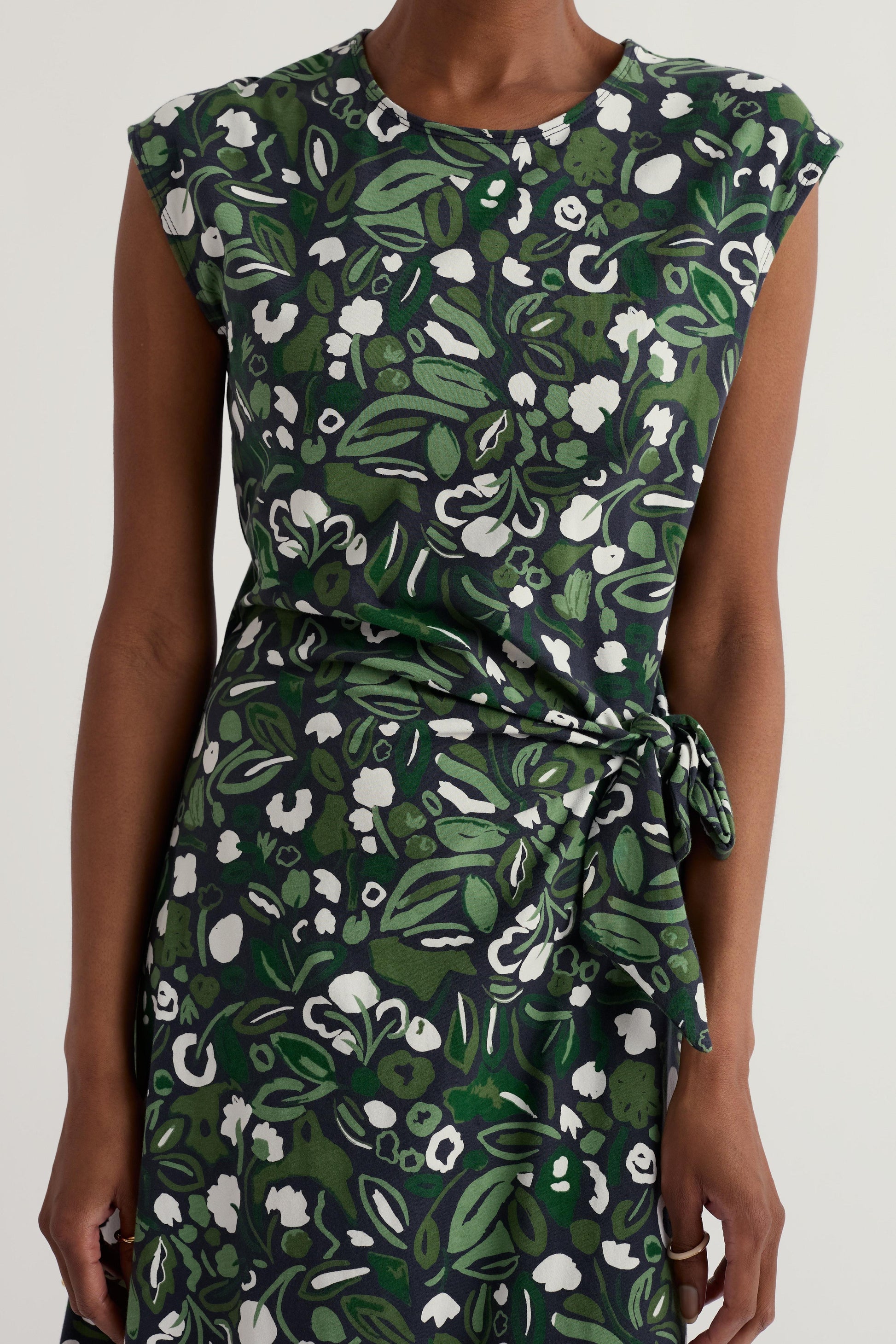 Green organic cotton floral dress worn by a model on a white background