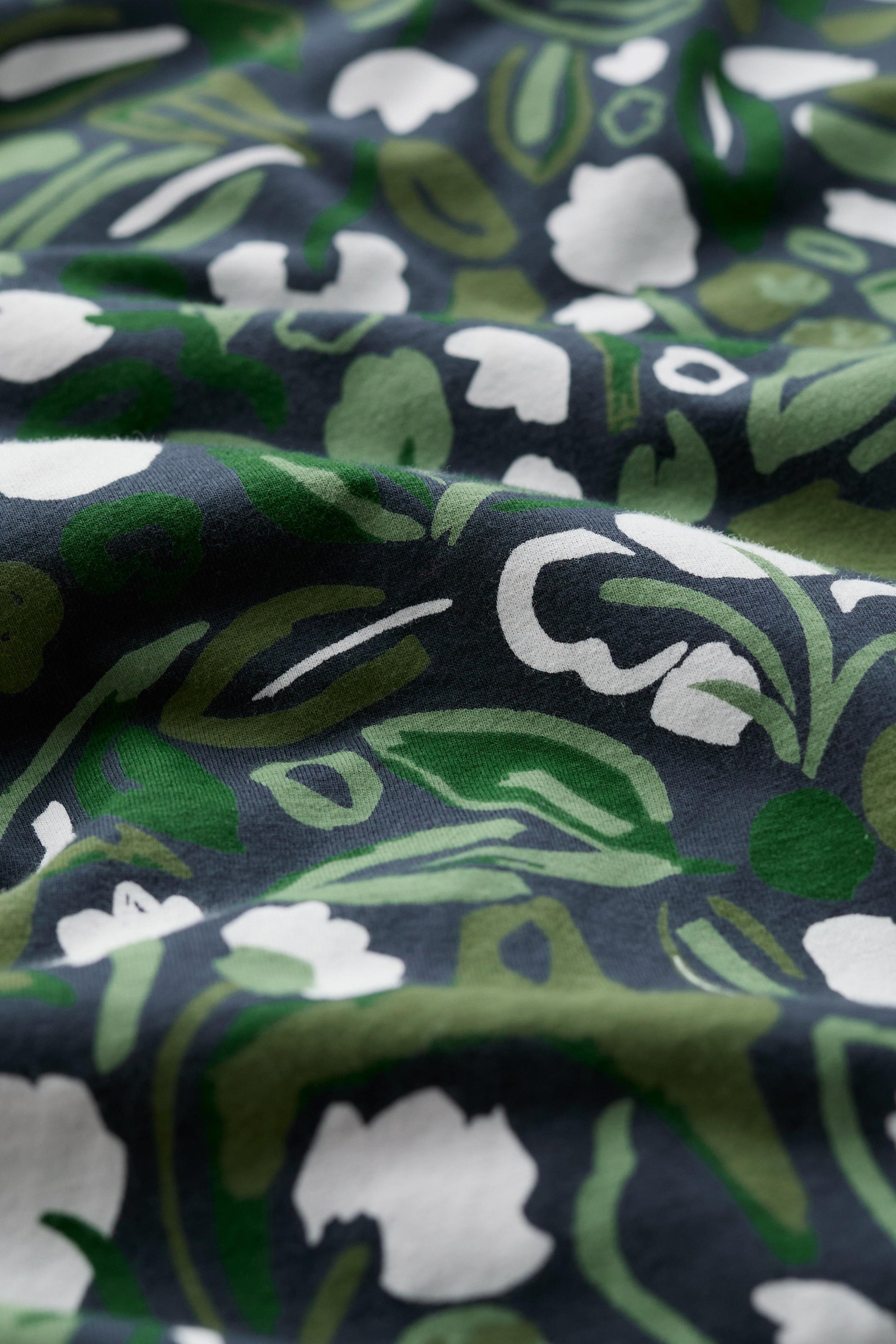 Close-up of organic cotton dress with green floral pattern 