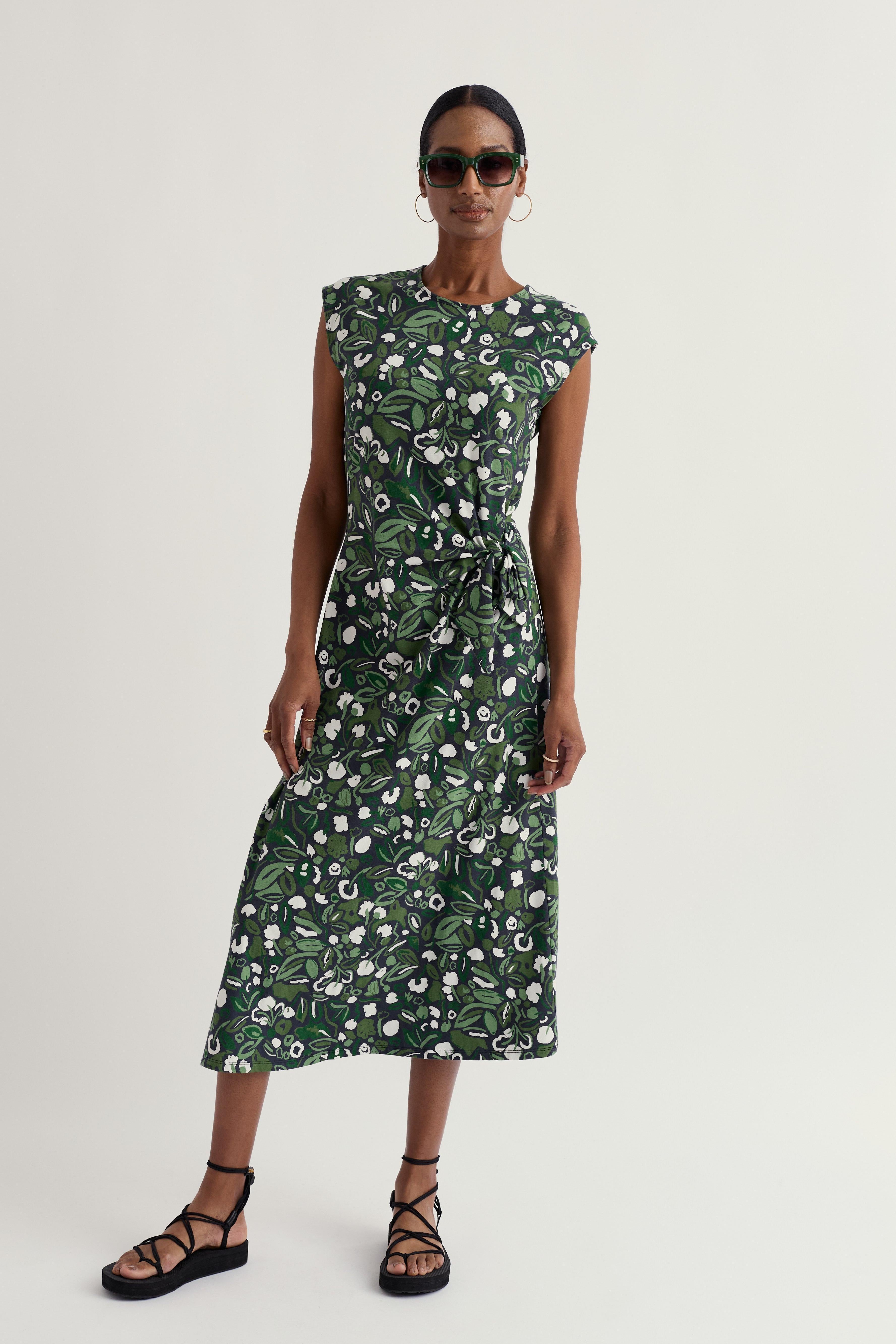 Woman wearing a green floral dress on a white background