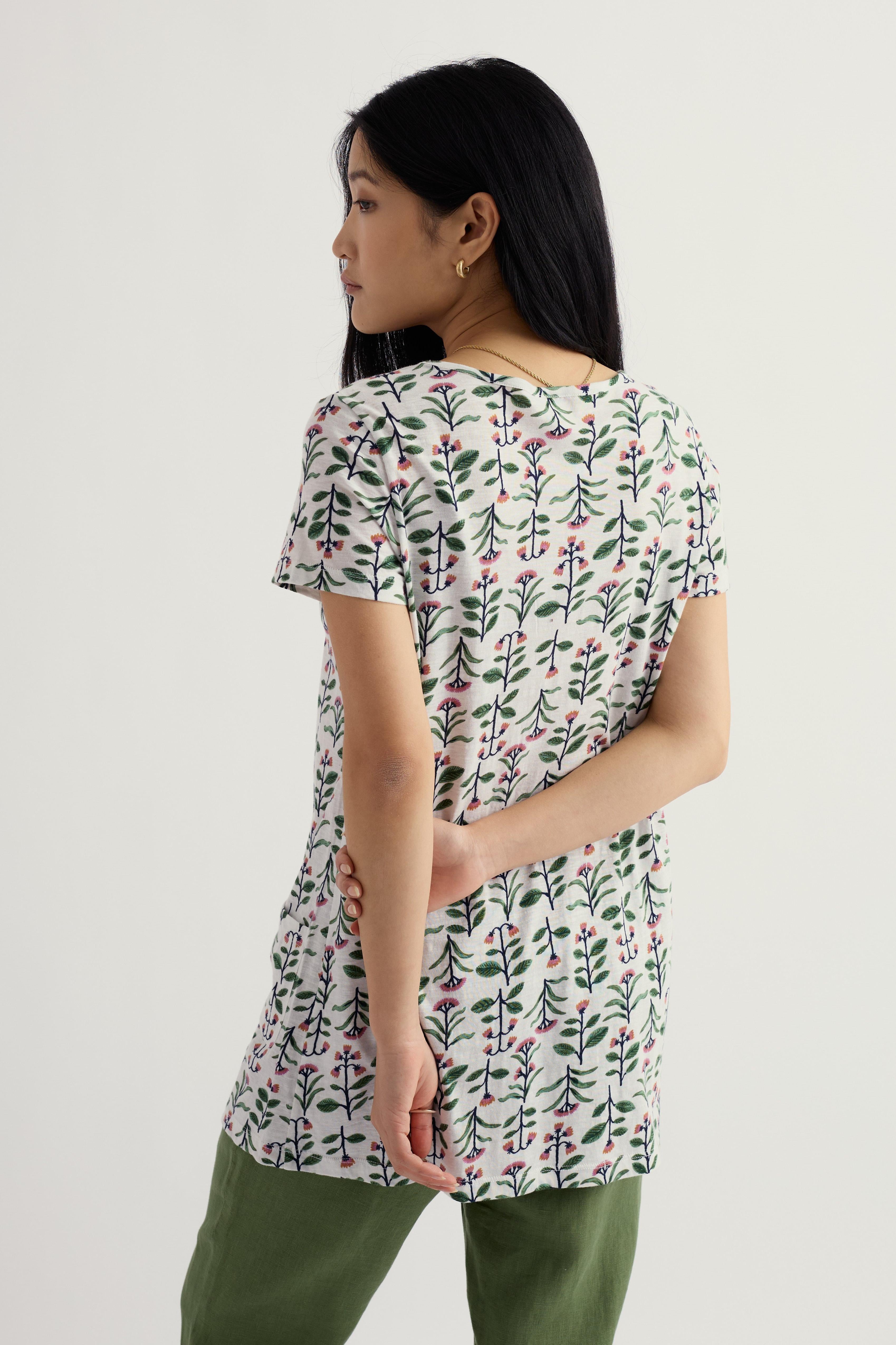 Woman wearing a floral-patterned organic cotton tunic on a plain background