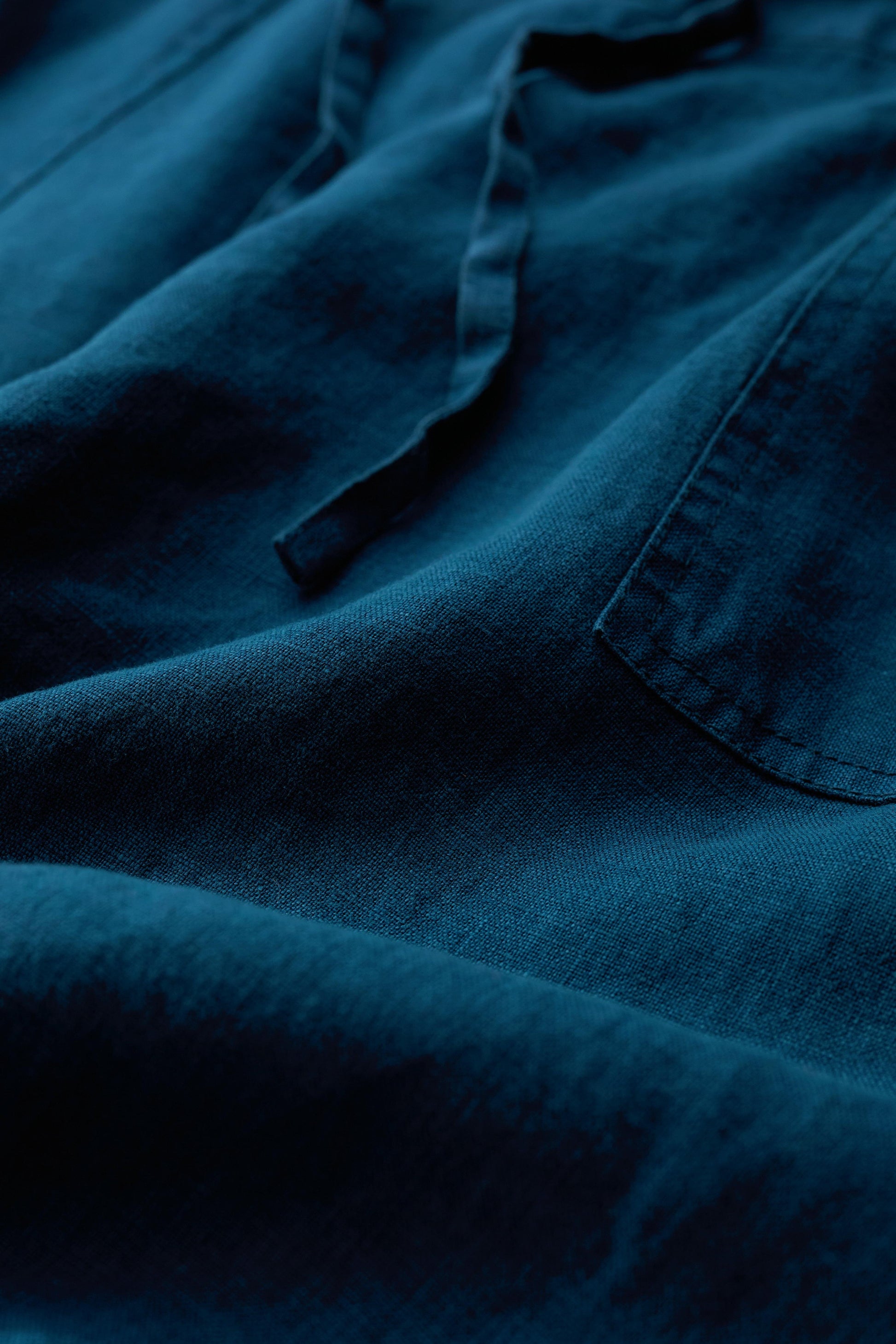 Close-up of blue linen fabric with visible stitching