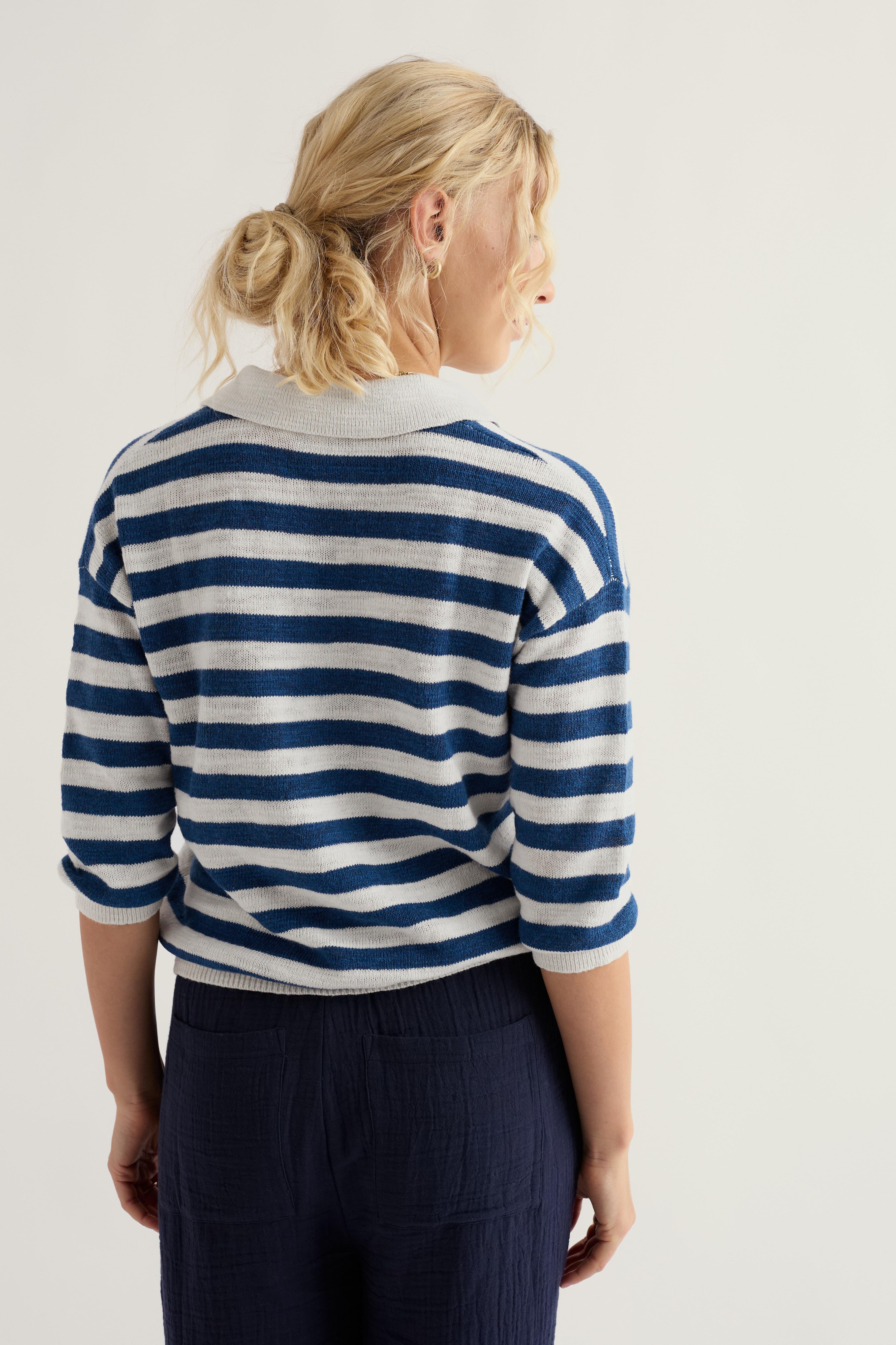 Woman wearing a blue and white striped sweater on a plain background
