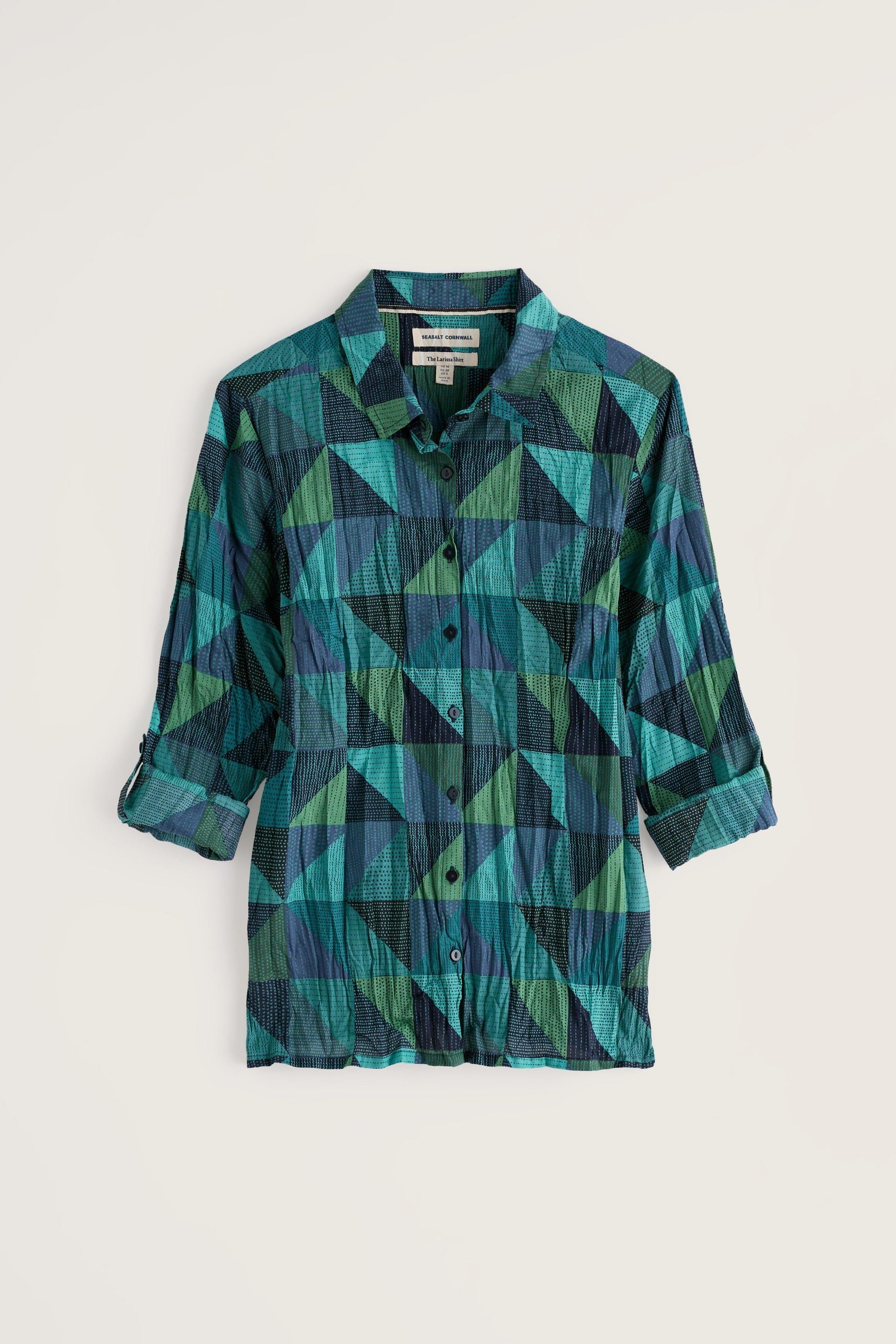 A long-sleeve button-up shirt with a geometric triangle pattern in shades of teal, green, and dark navy, displayed flat against a light beige background.
