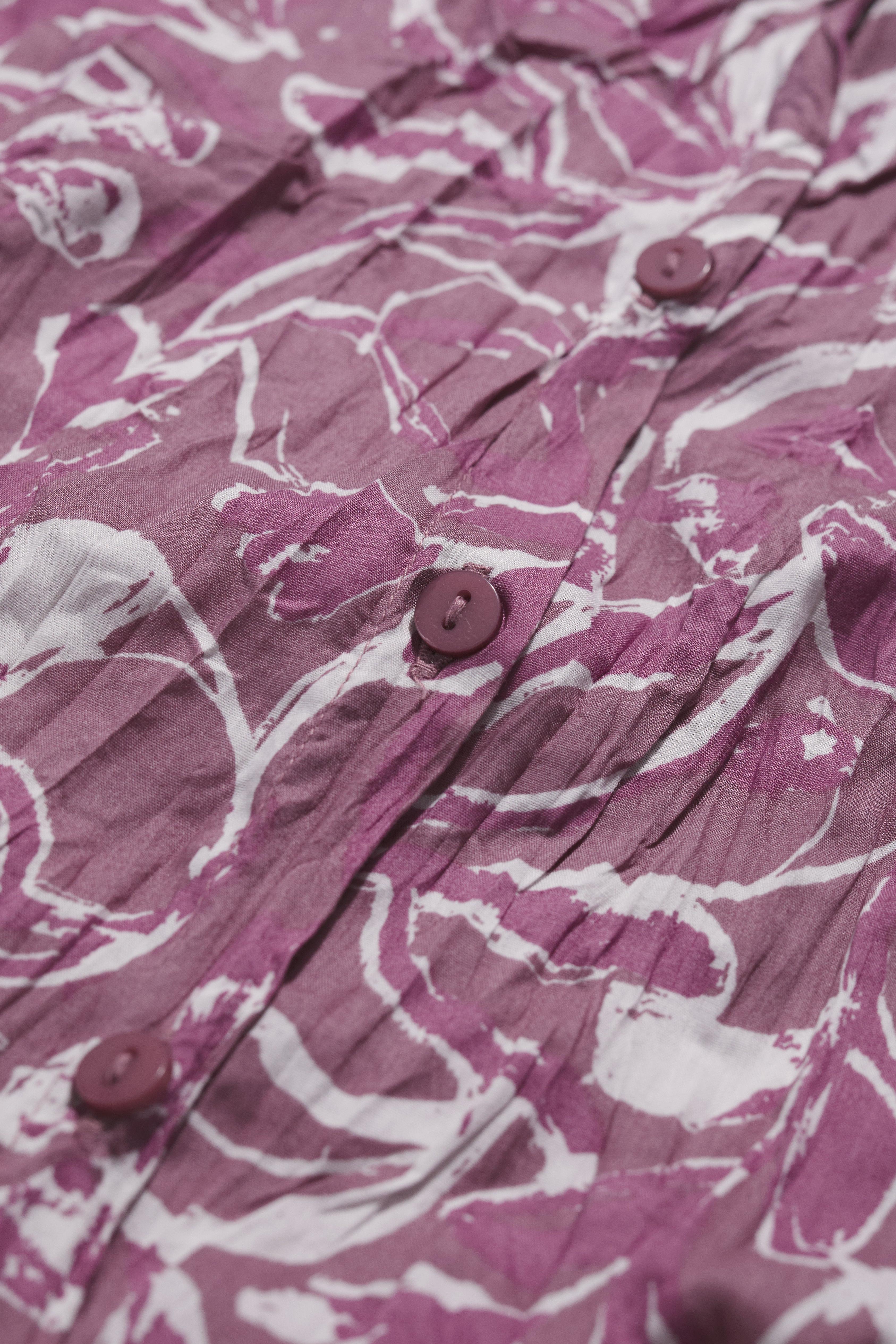 Close-up of a purple and white patterned shirt with buttons.