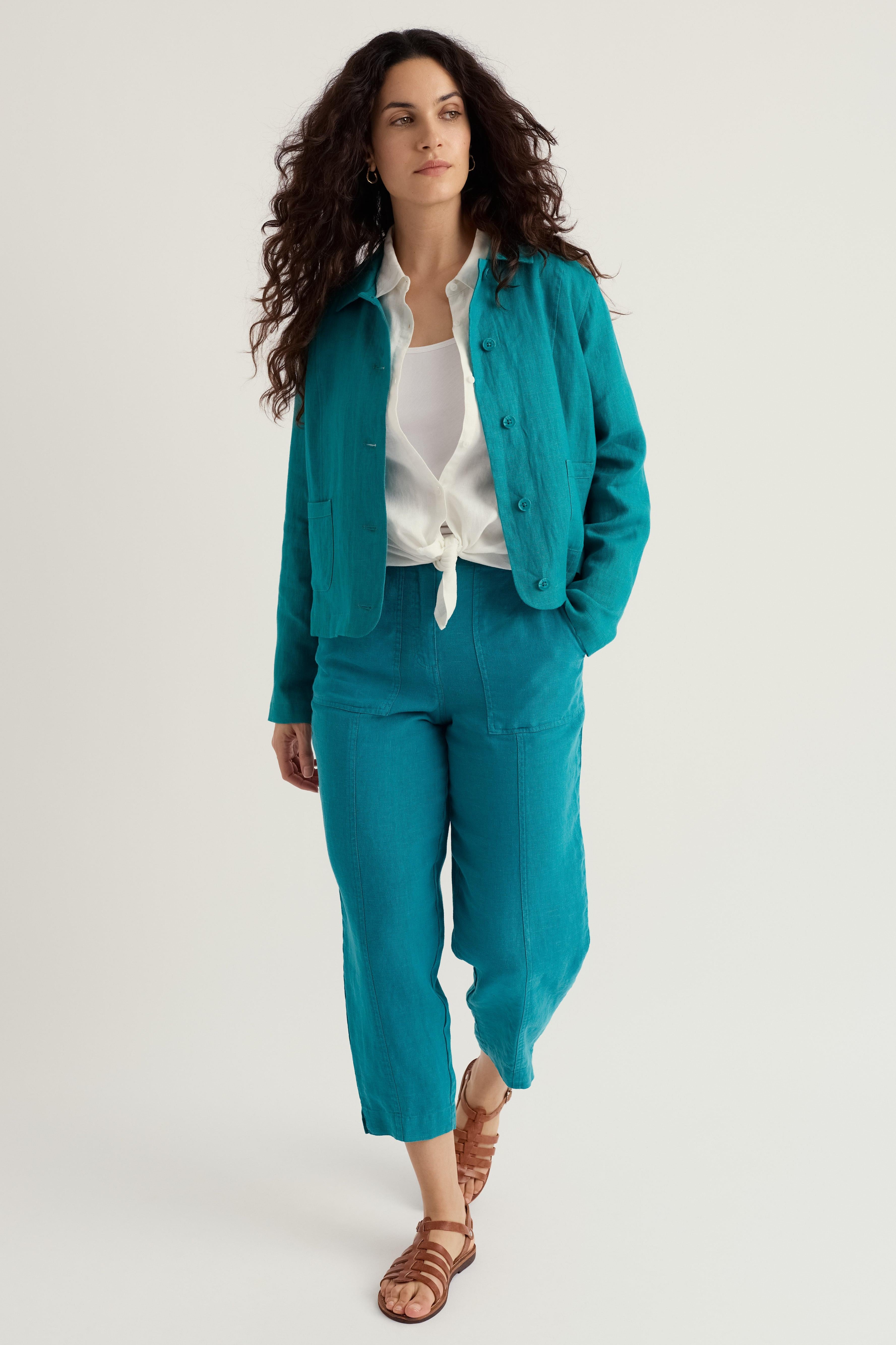 Woman wearing a teal linen outfit with a white background