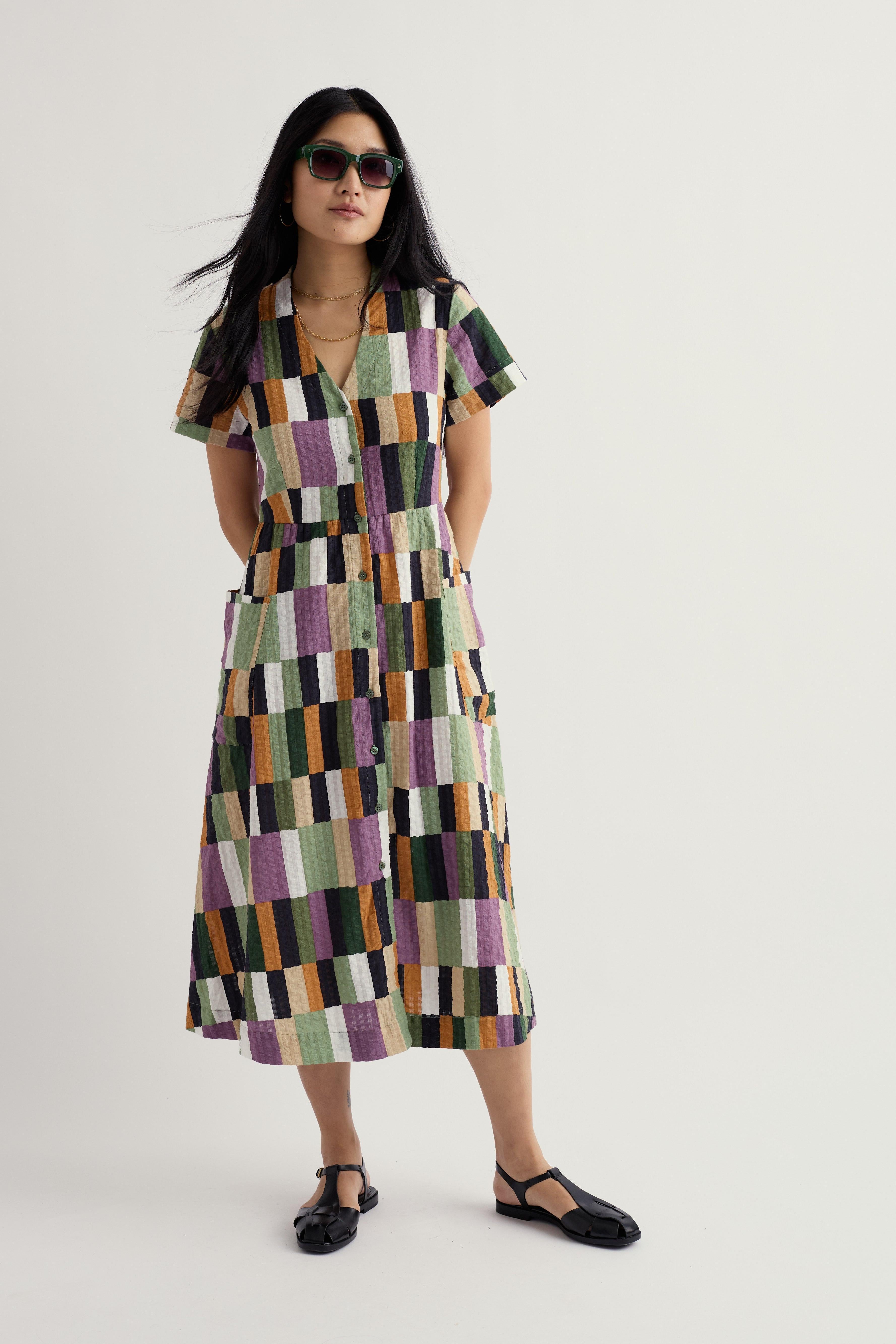 Woman wearing a patterned Seasalt dress on a white background