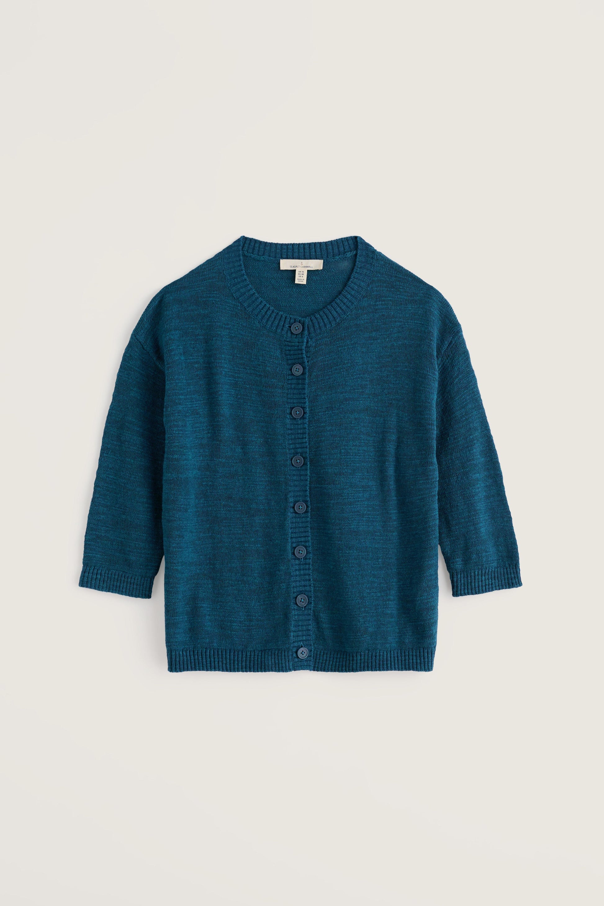Blue organic cotton cardigan on a light beige background