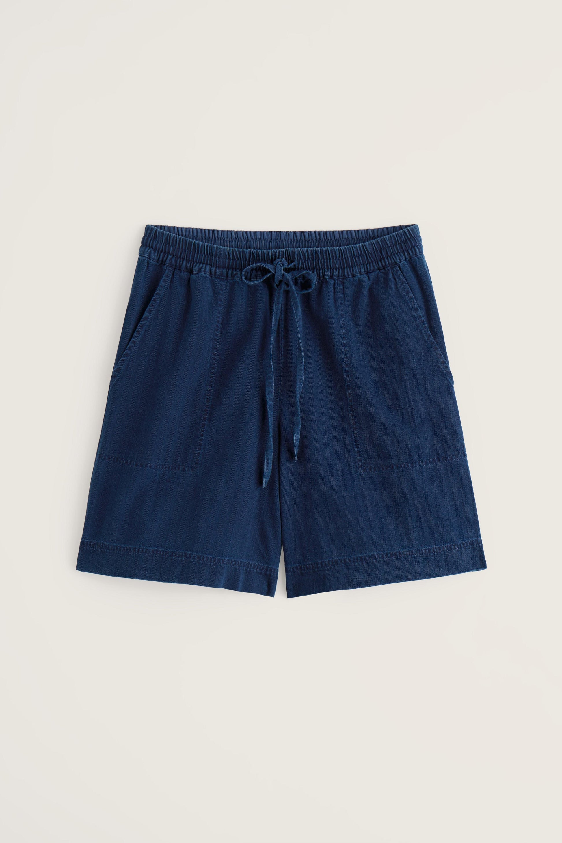 Navy organic denim shorts with a drawstring on a beige background