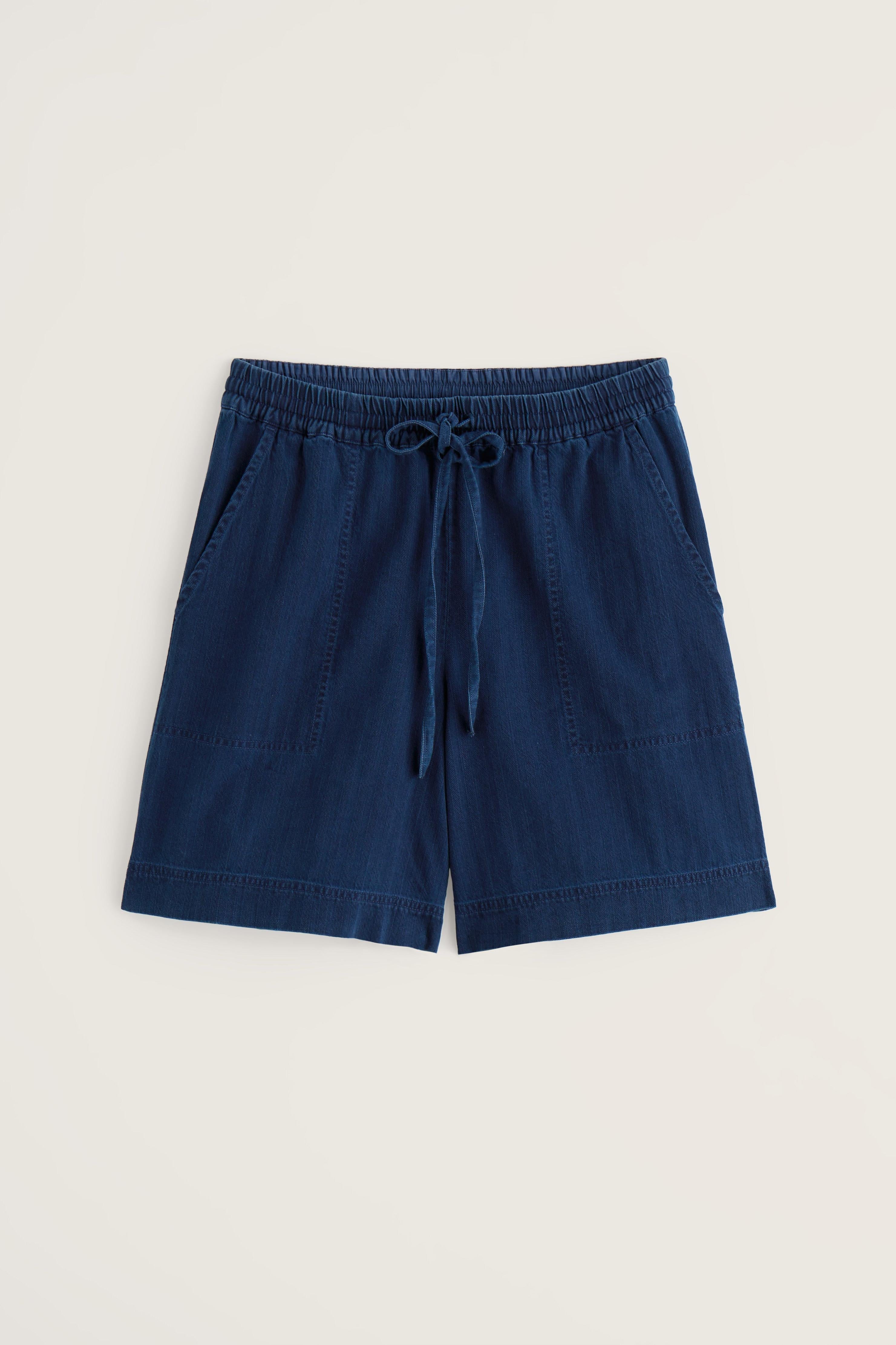 Navy organic denim shorts with a drawstring on a beige background