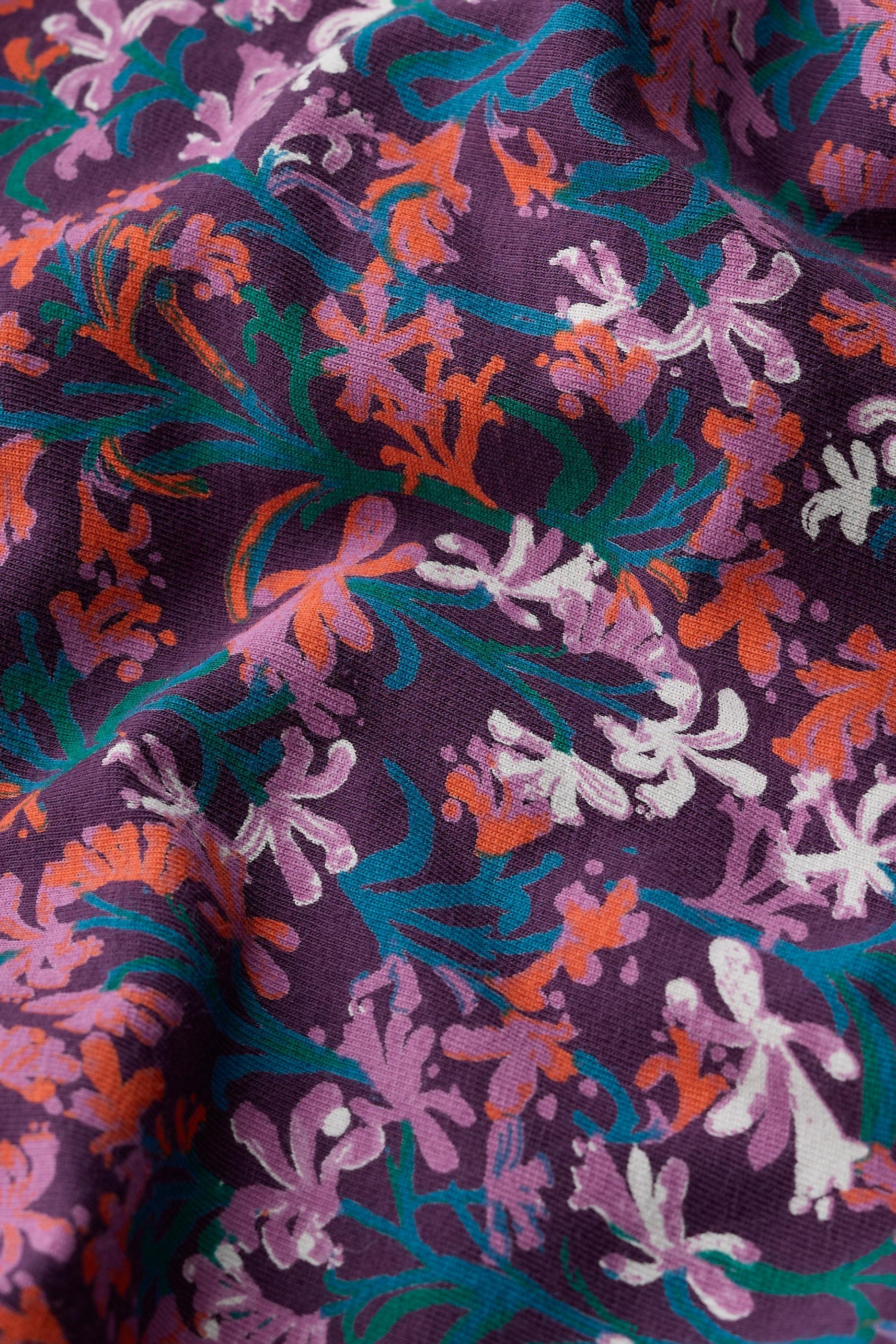 Close-up of floral patterned fabric with purple background