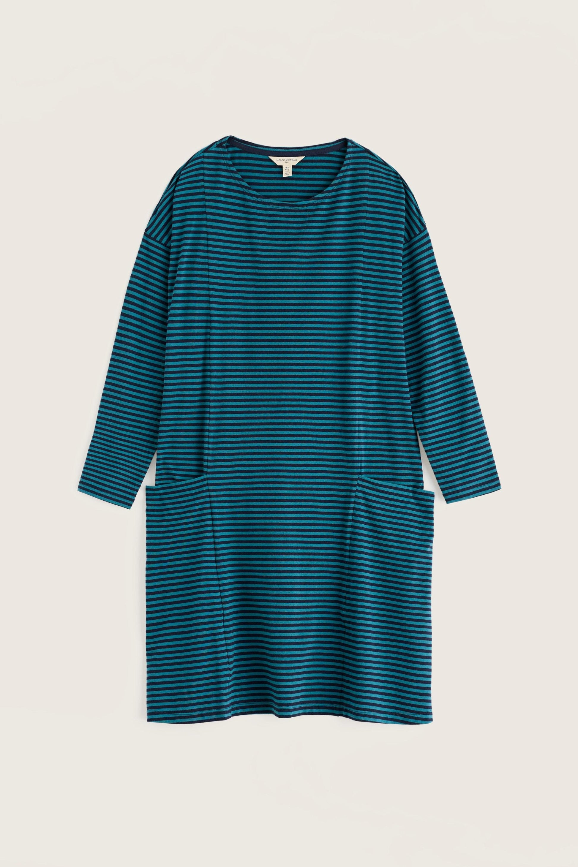 A long-sleeve, crew-neck dress with horizontal teal and dark gray stripes, featuring two large patch pockets at the waist, shown against a solid light beige background.
