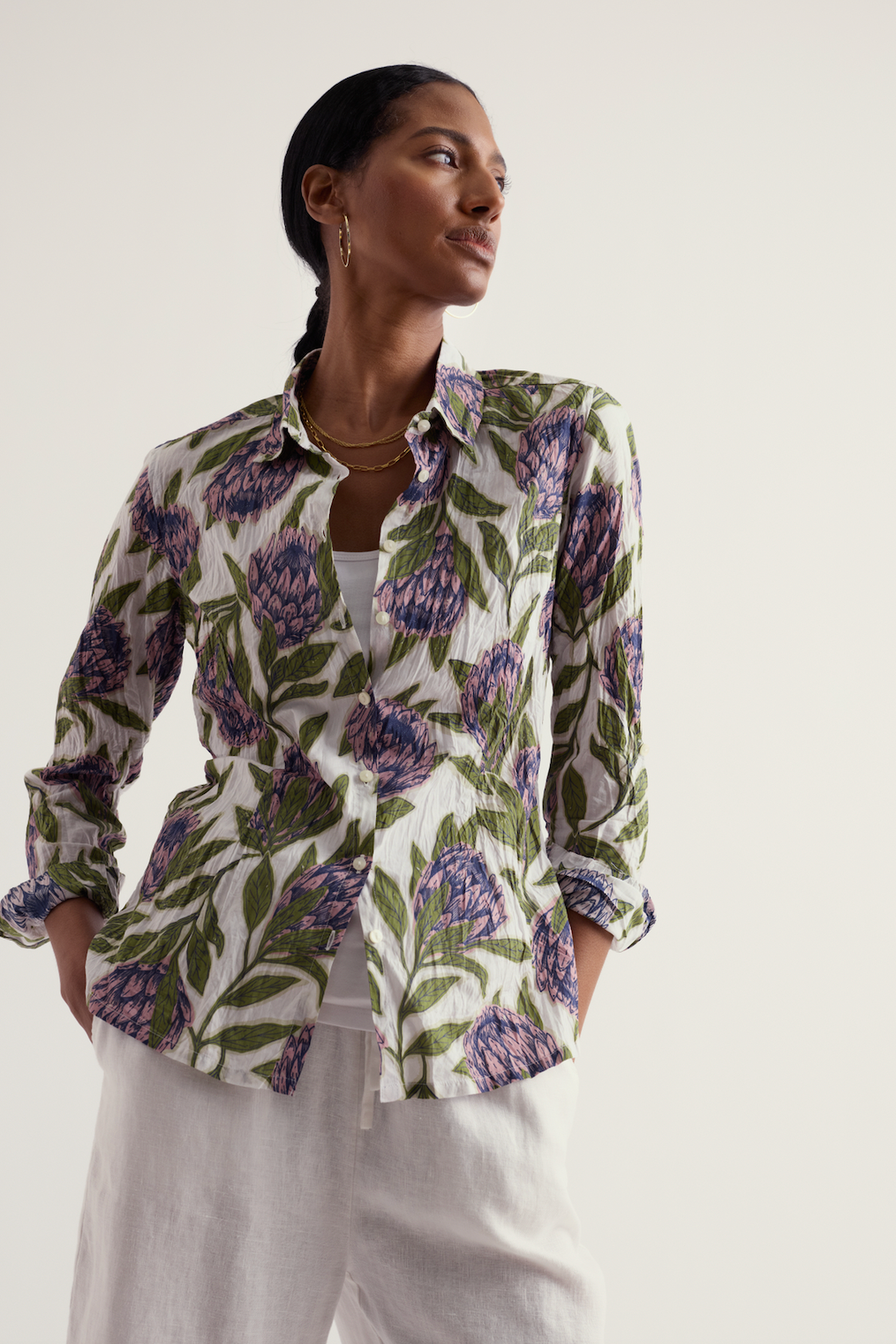 Woman wearing a floral organic cotton shirt on a plain background