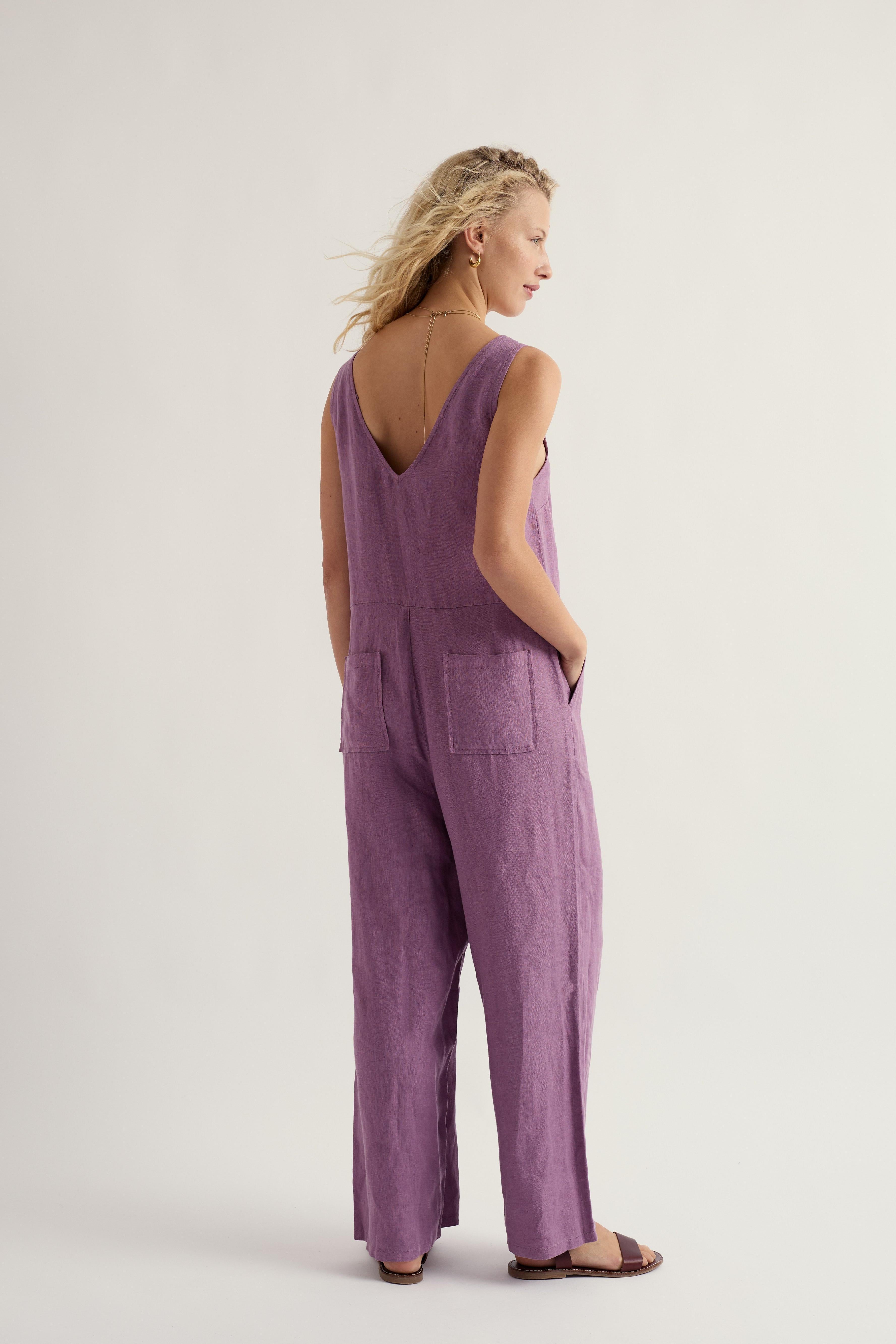 Woman wearing a purple linen jumpsuit on a white background