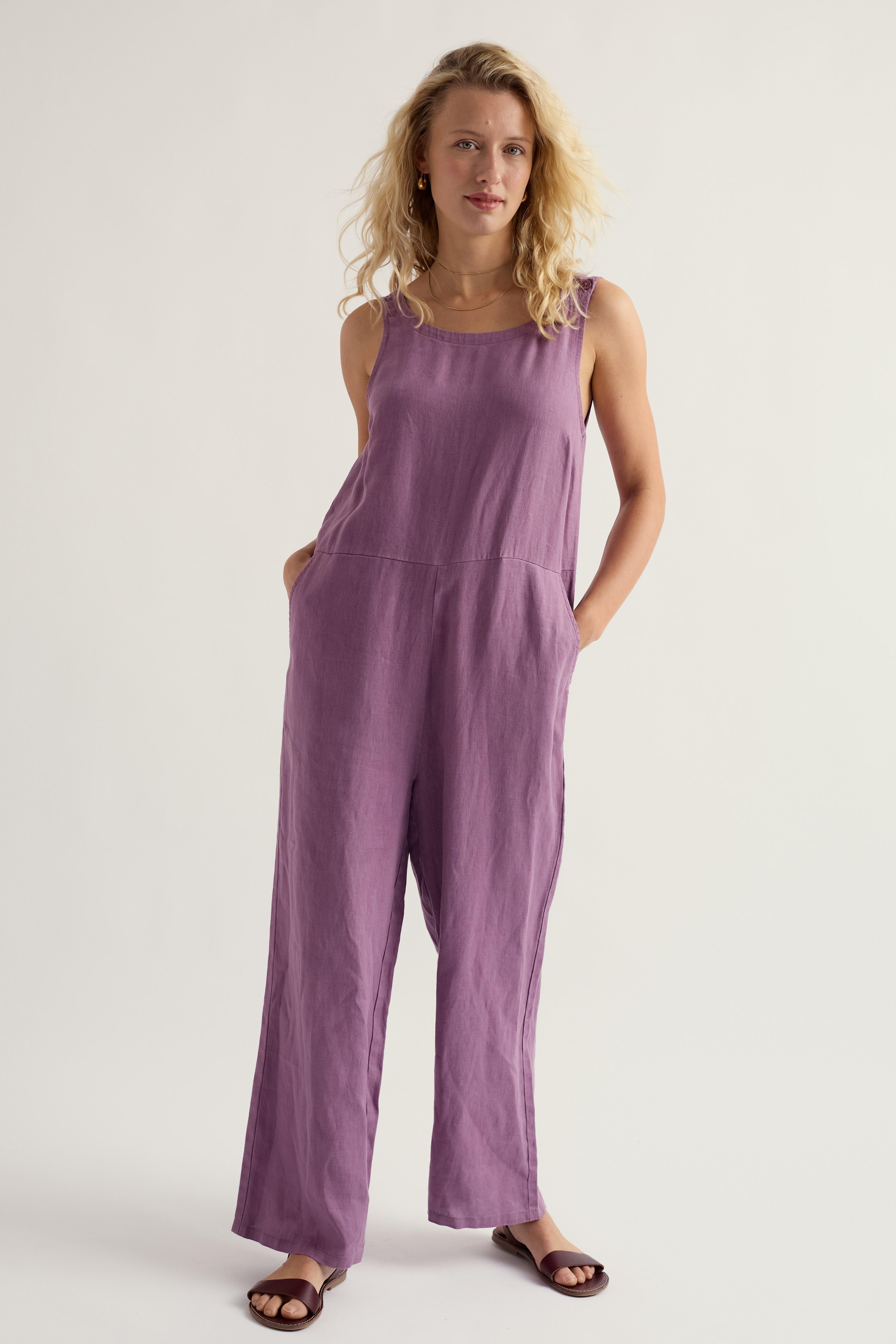 Woman wearing a purple linen jumpsuit on a white background