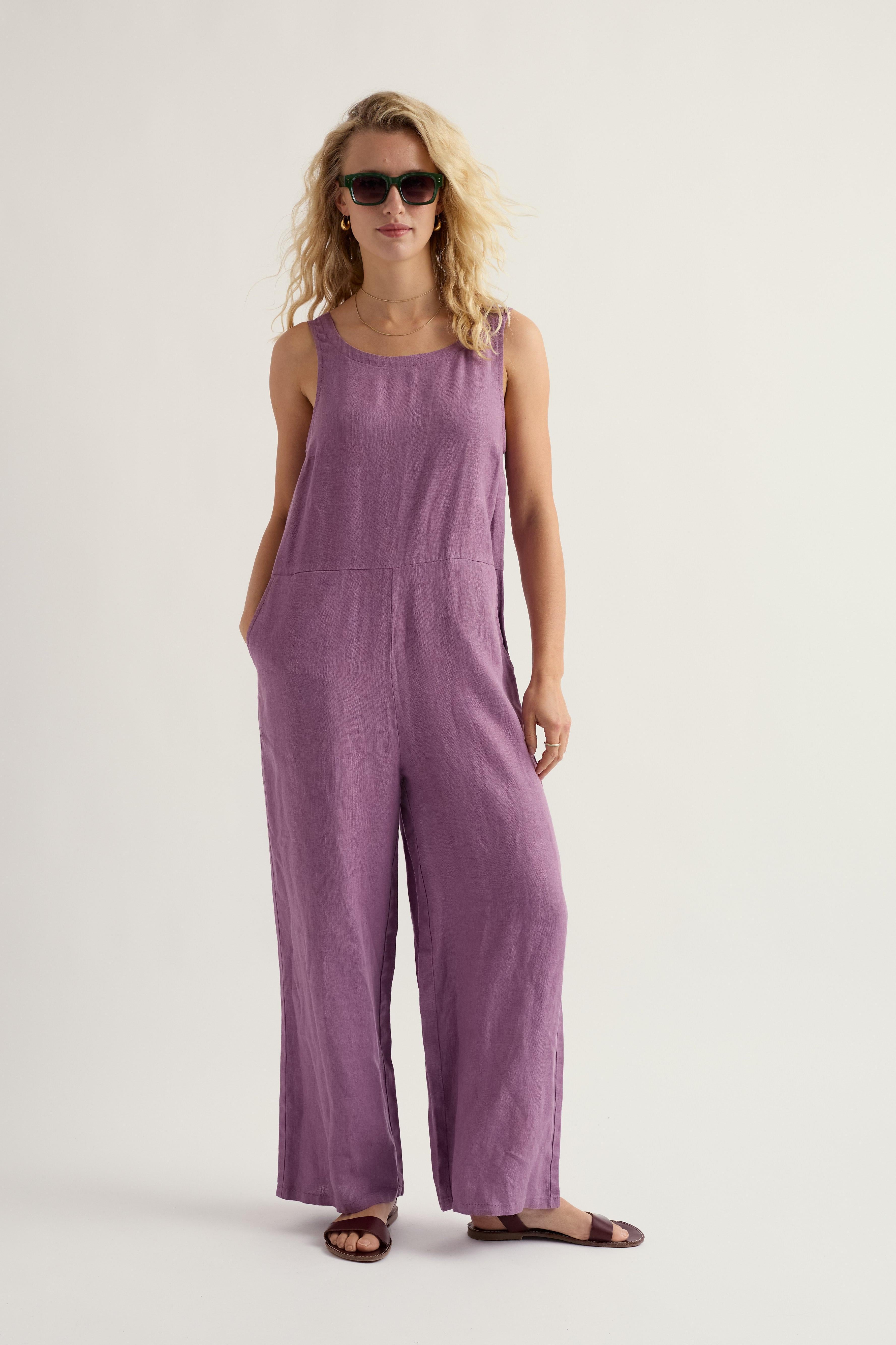 Woman wearing a purple linen jumpsuit on a white background