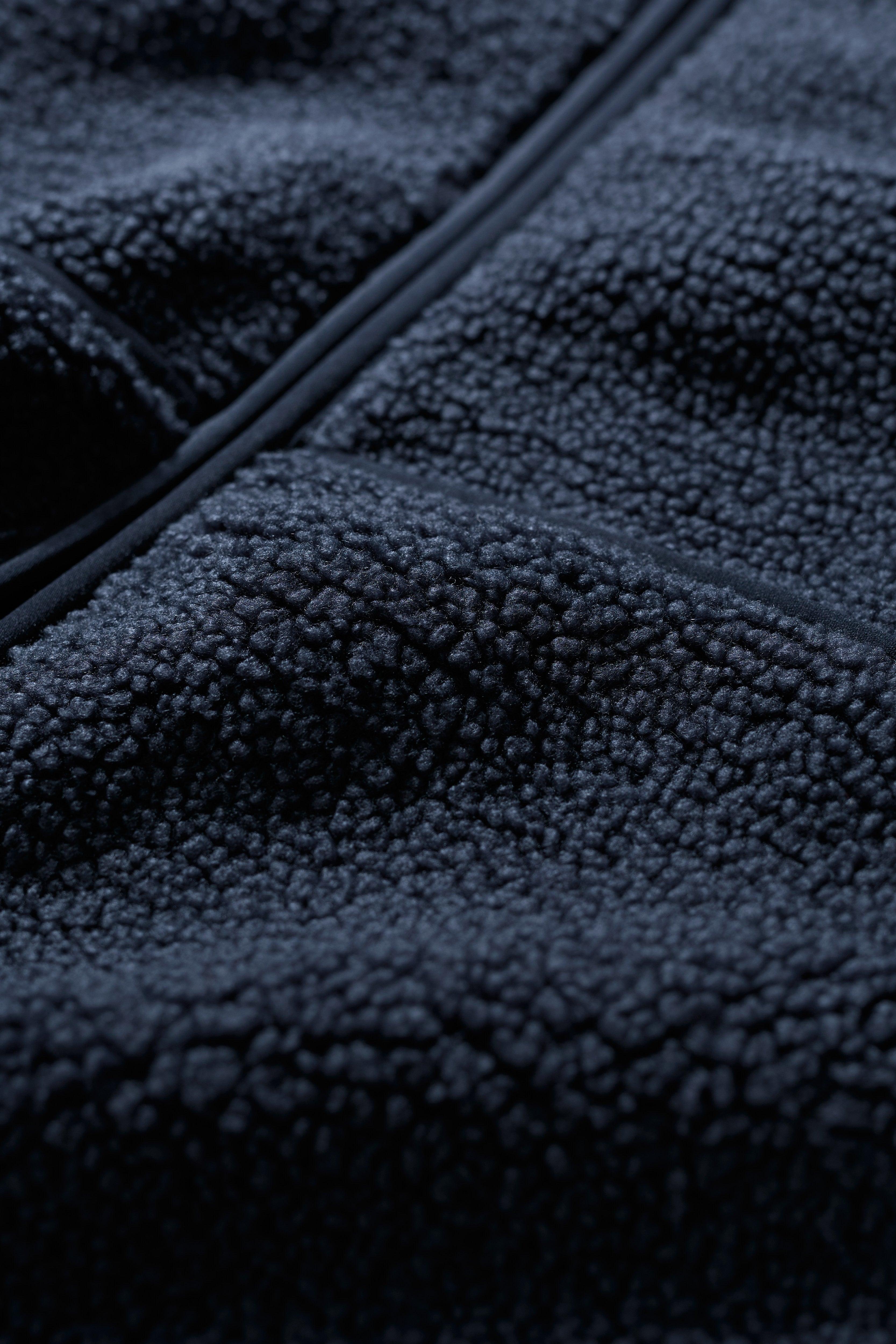 Close-up of dark blue fleece fabric with a zipper