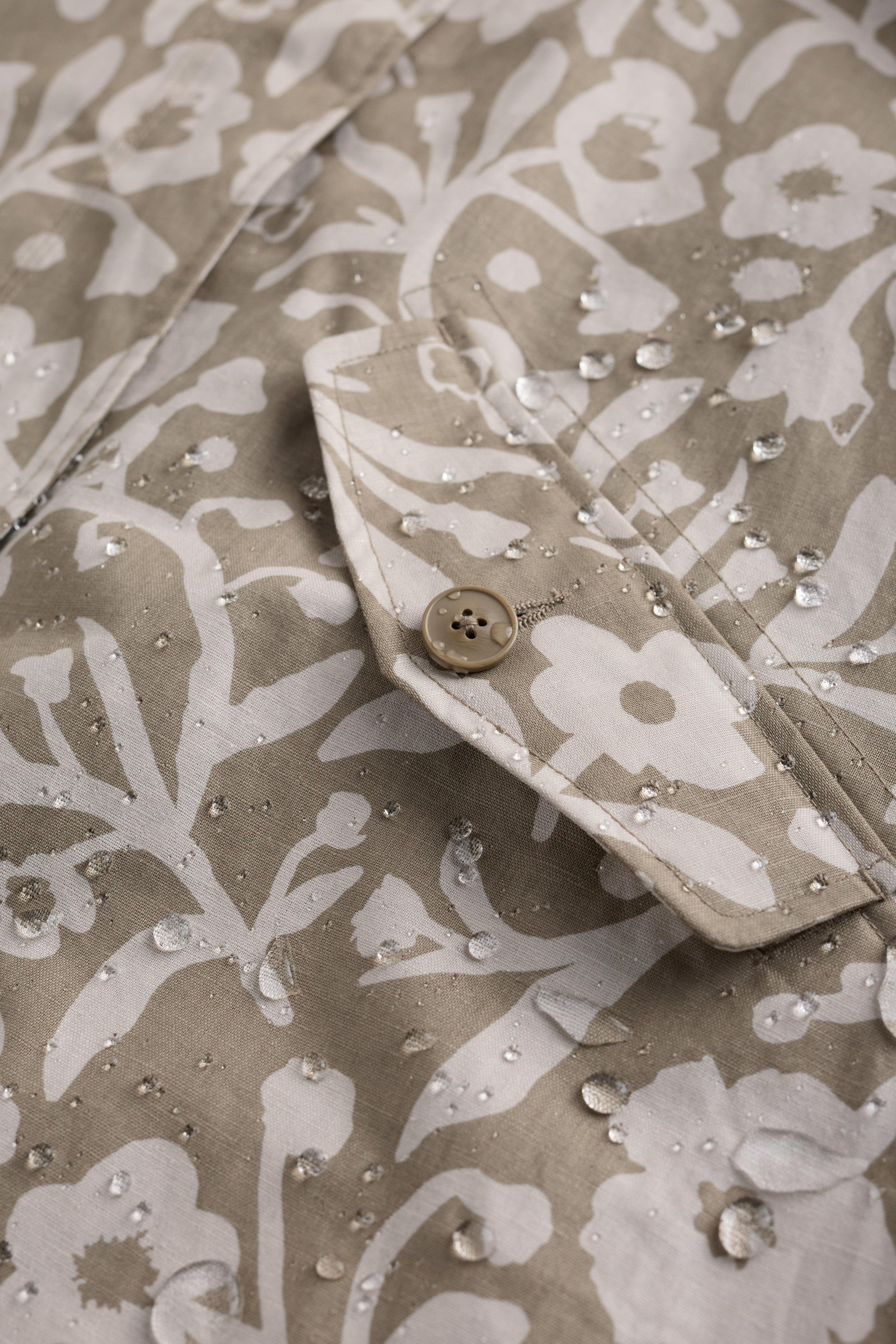 Floral patterned fabric with water droplets on a beige background