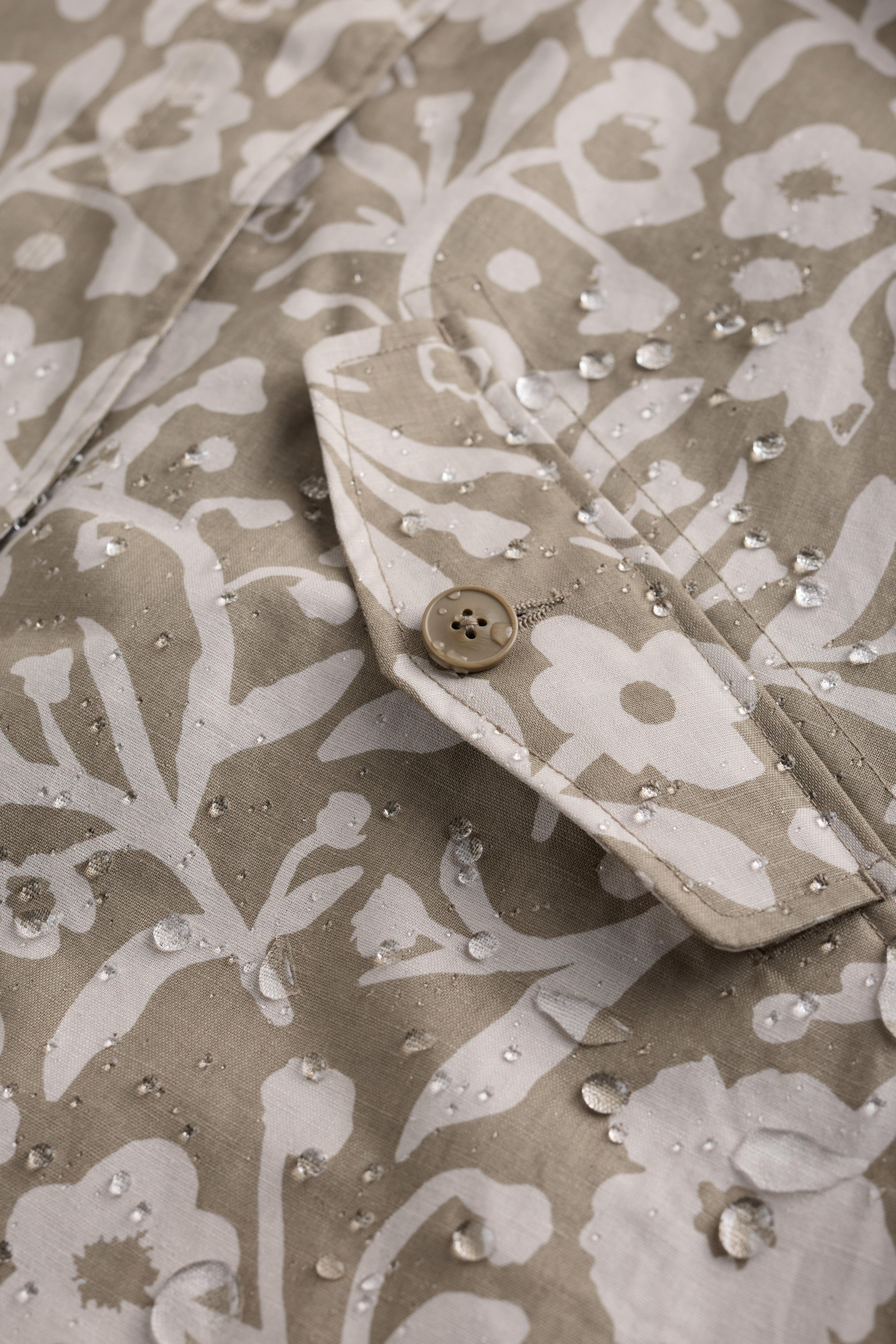 Floral patterned fabric with water droplets on a beige background