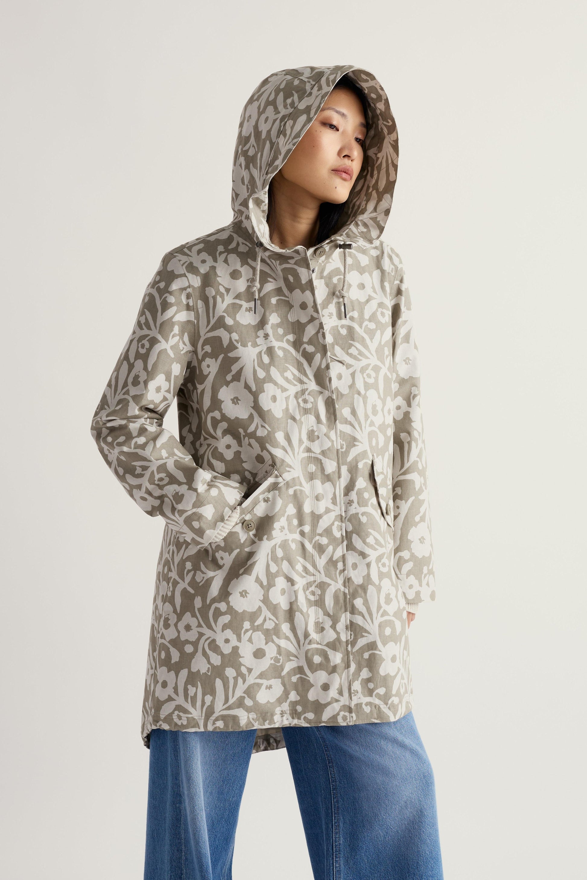 Person wearing a floral-patterned raincoat on a plain background