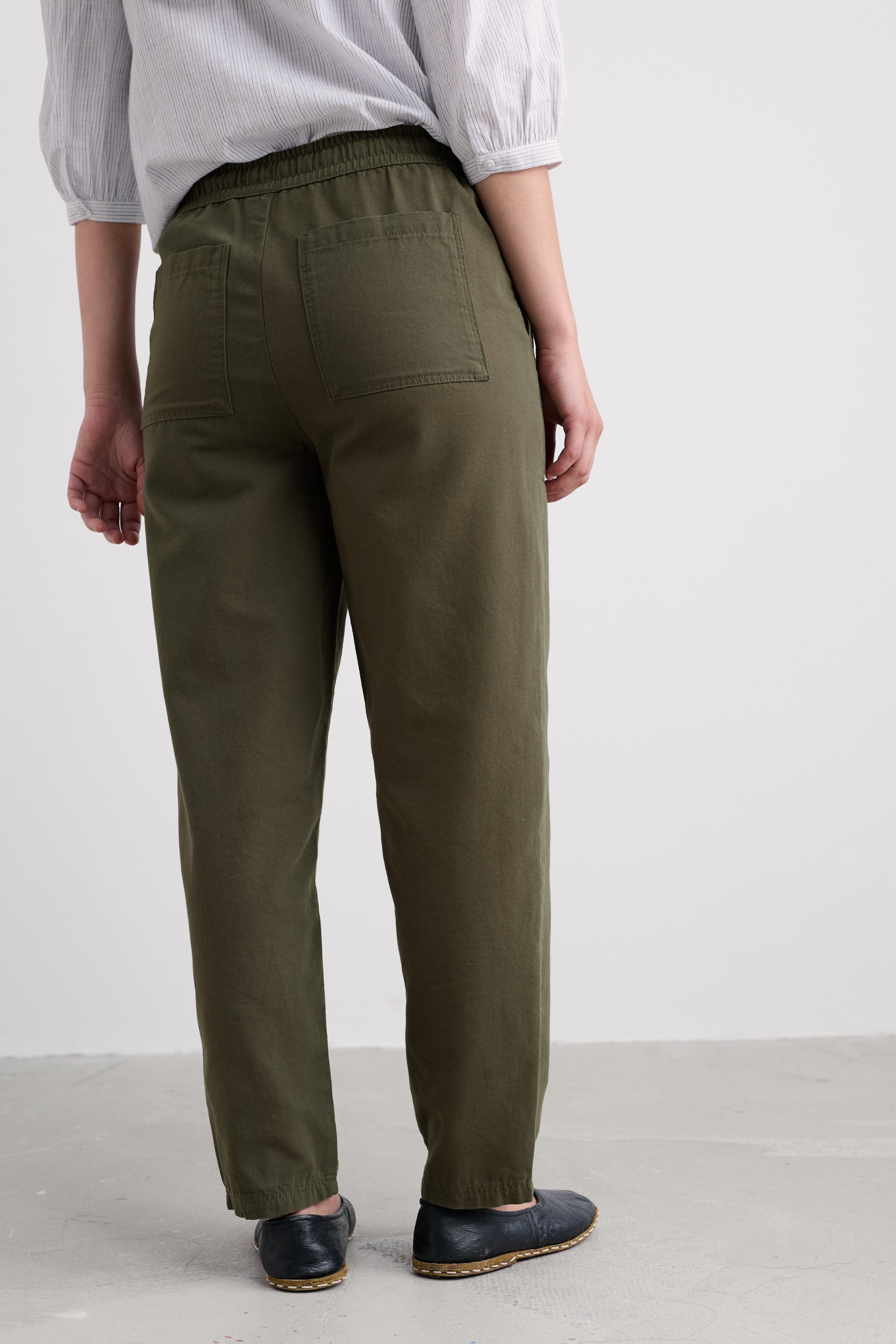 Person wearing olive green pants on a plain background