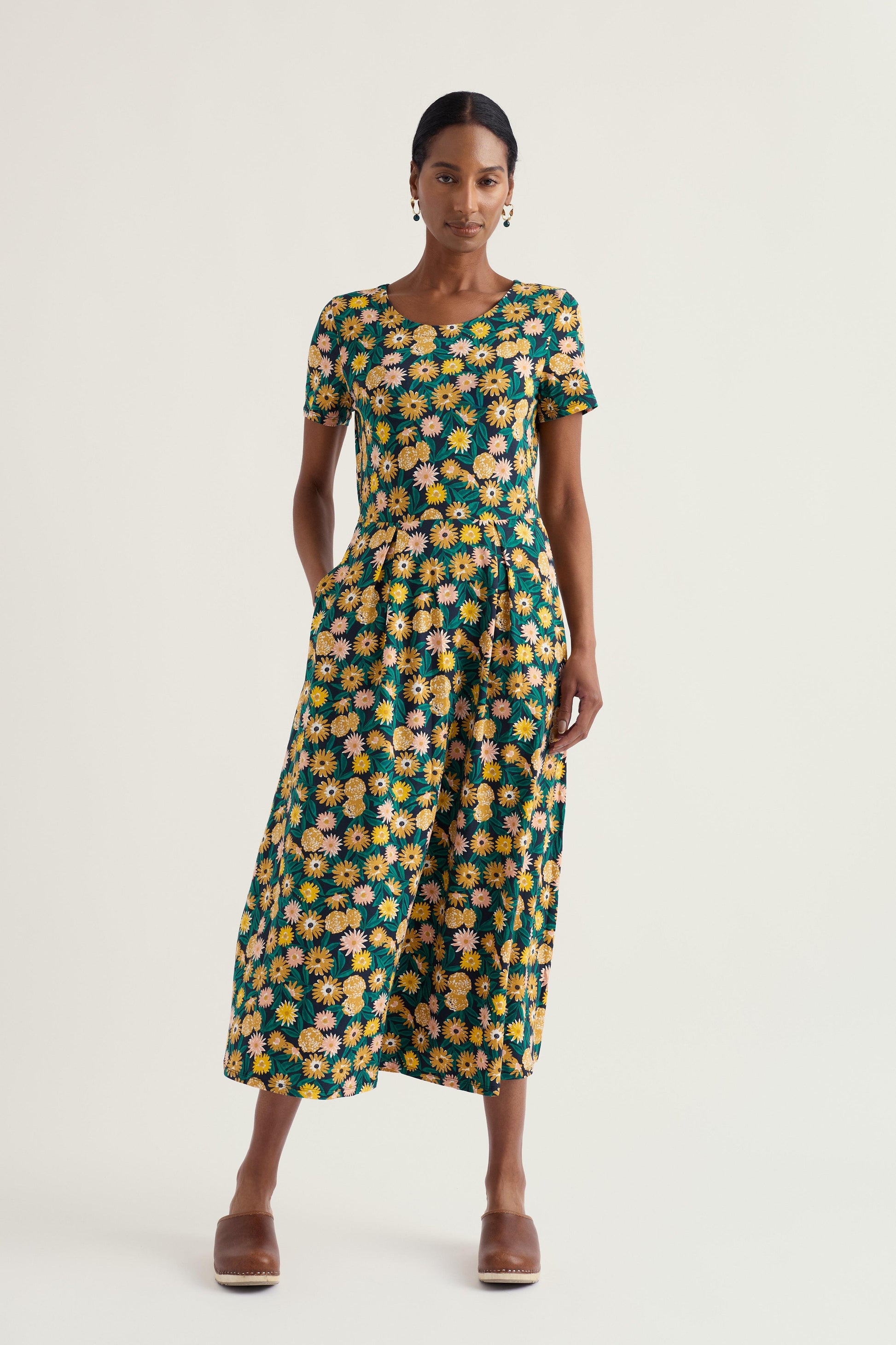 Woman wearing a floral Seasalt dress on a white background