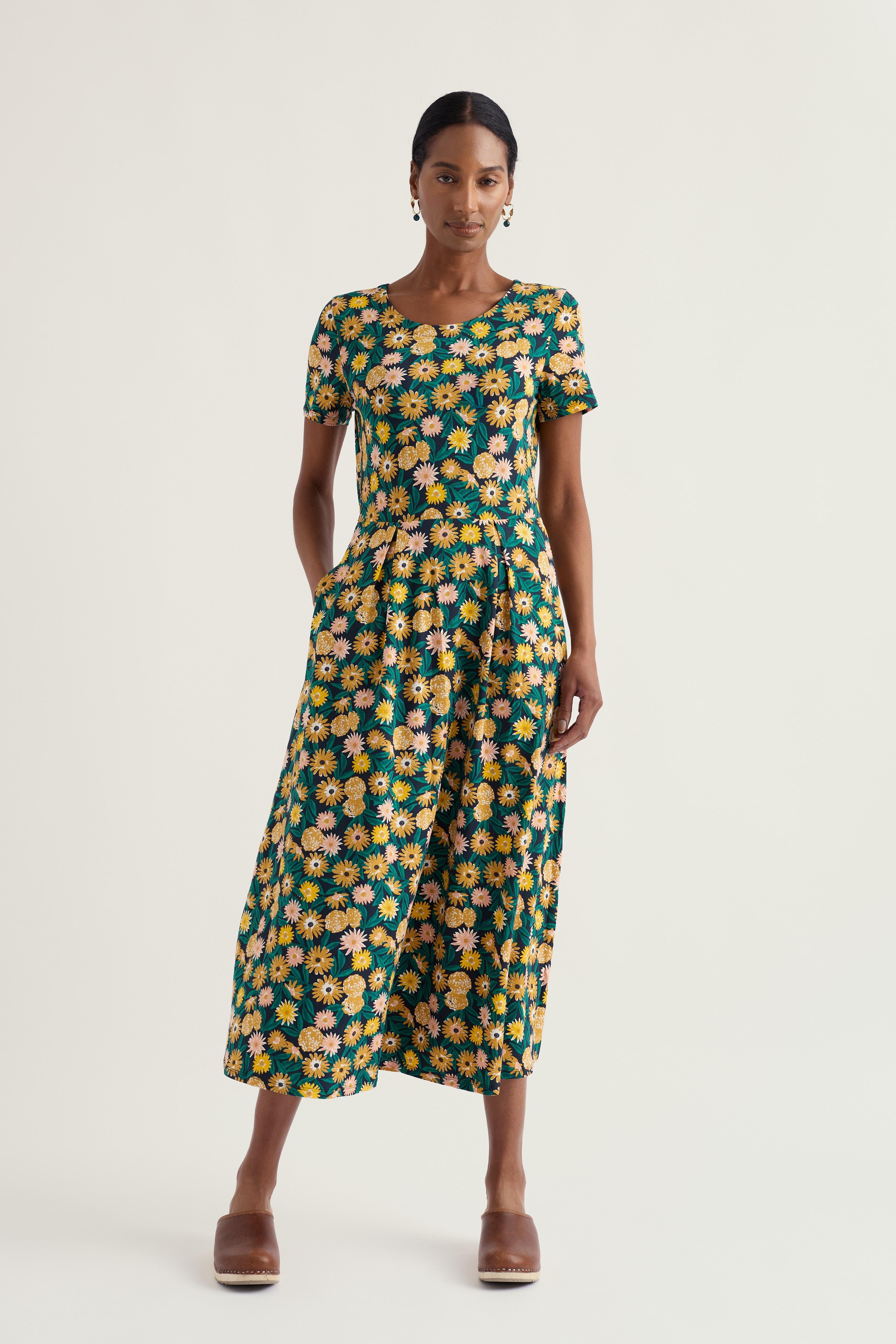 Woman wearing a floral Seasalt dress on a white background