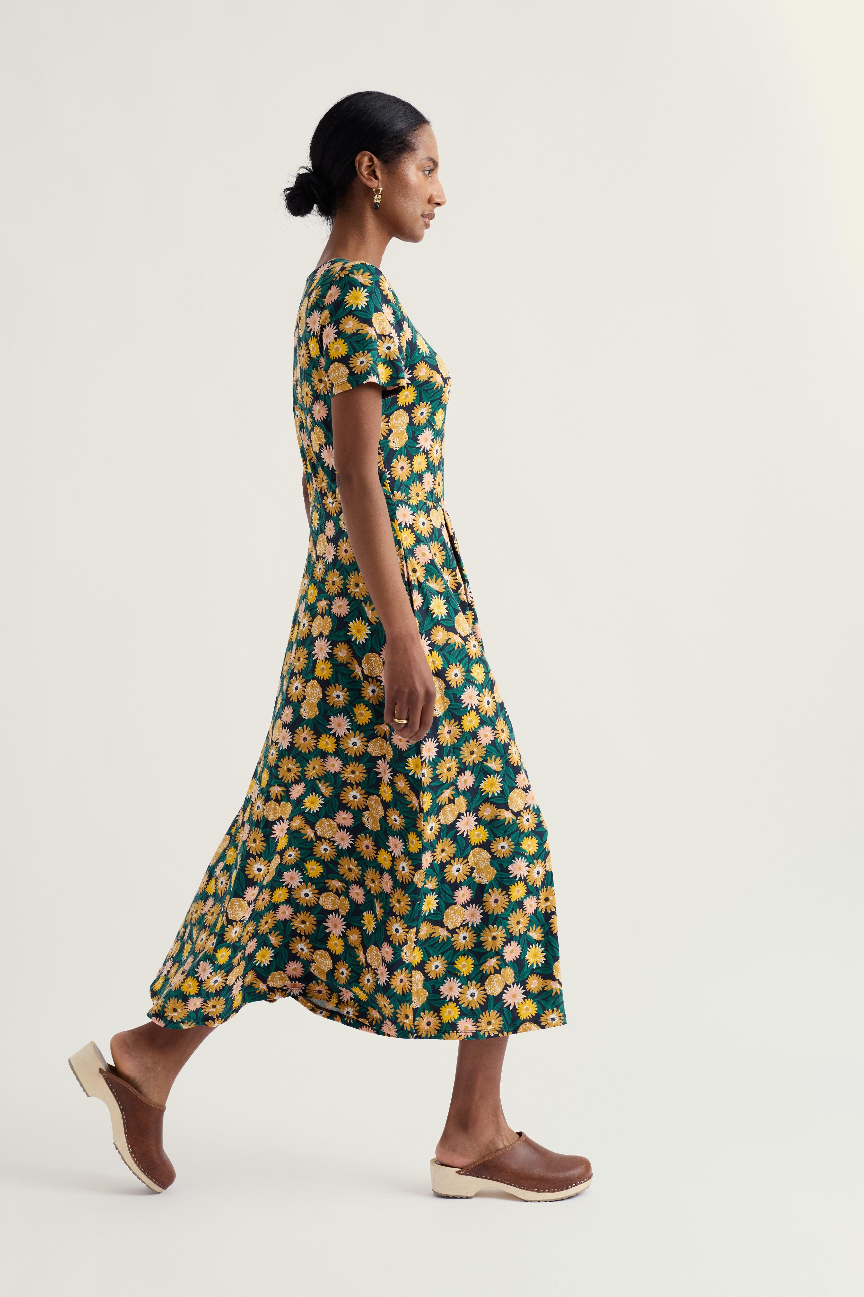 Woman wearing a floral midi dress on a white background