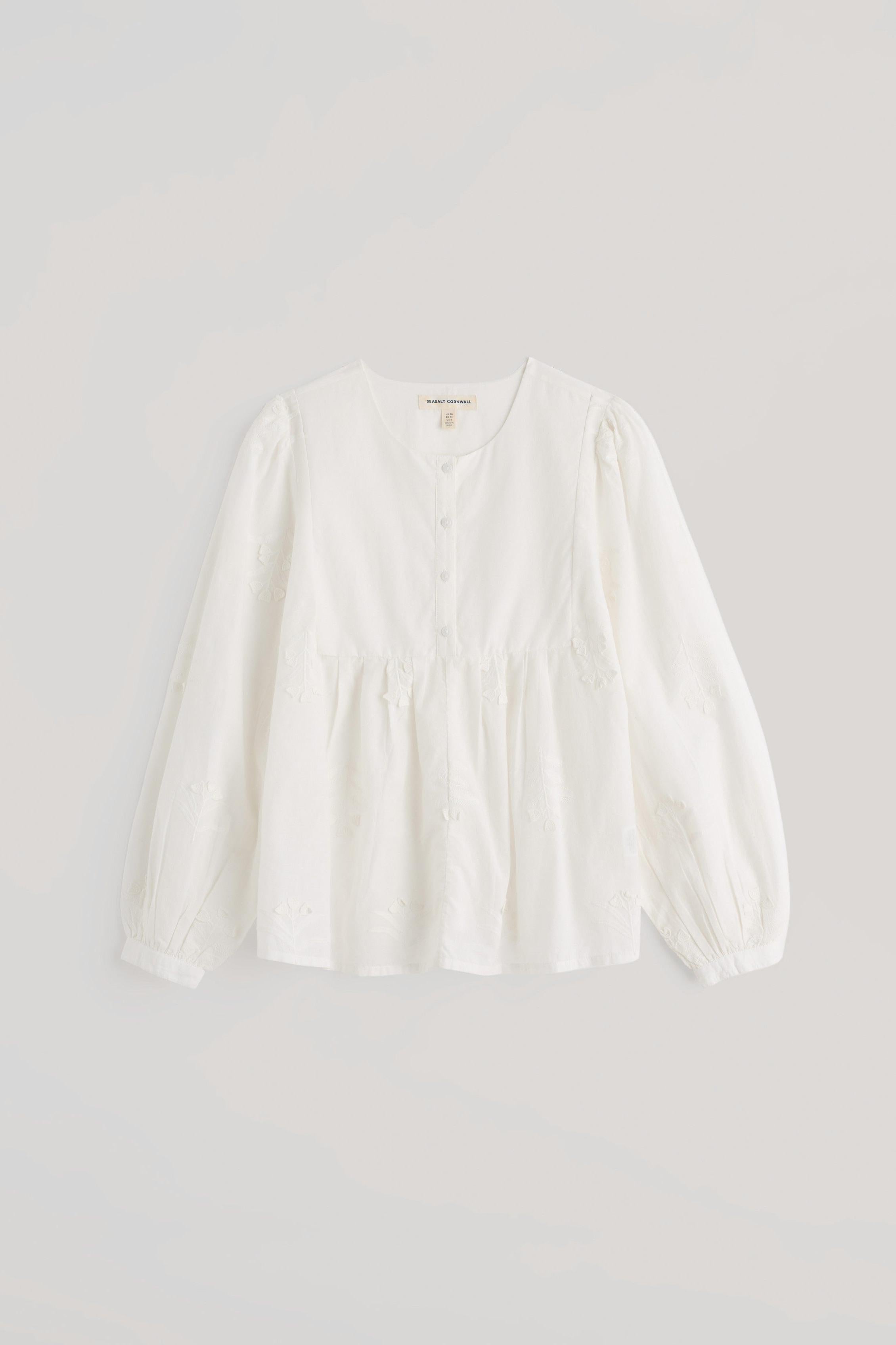 A white long-sleeve blouse with a gathered waist and buttoned neckline, displayed flat against a light gray background.