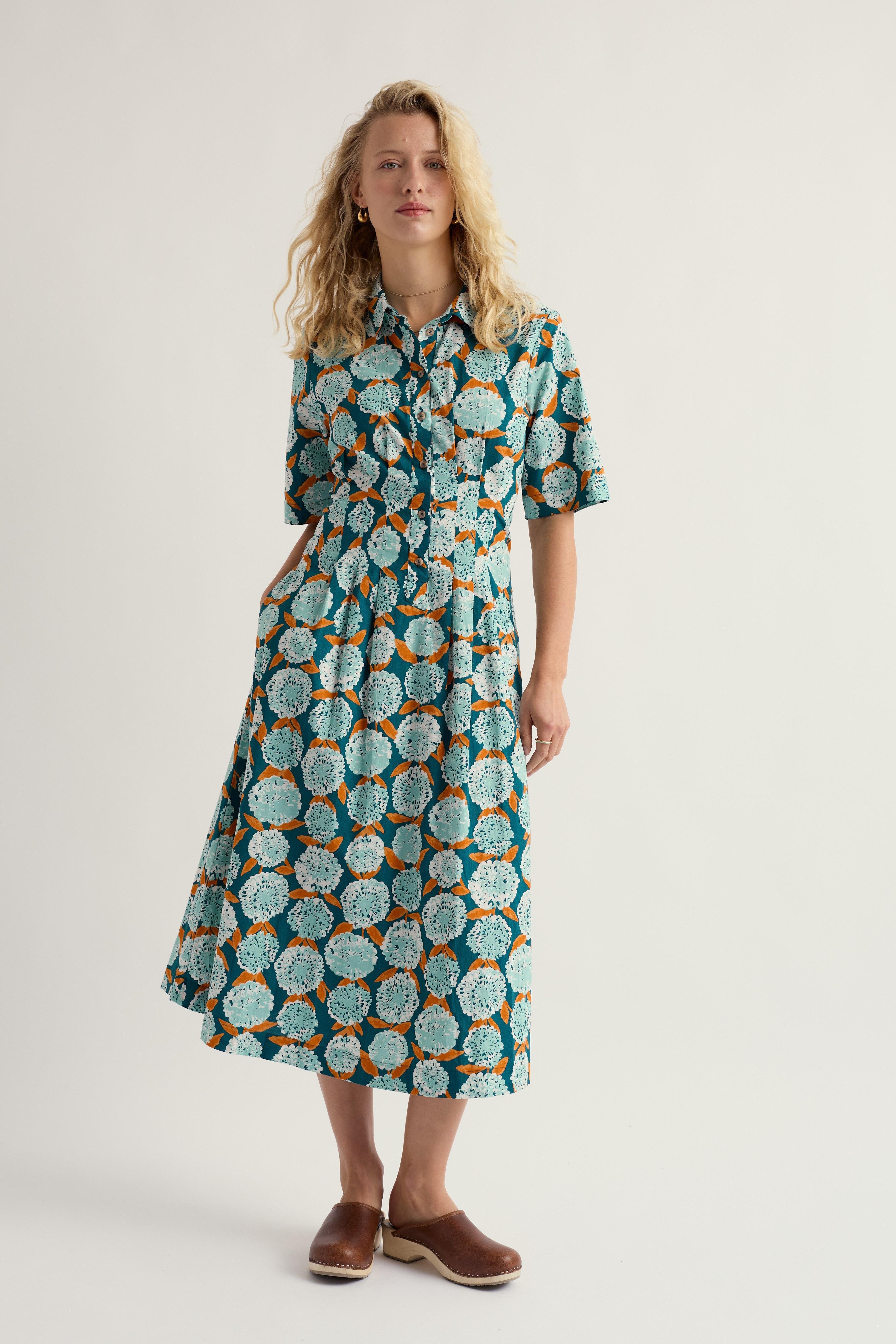 Woman wearing a floral organic cotton dress on a plain background