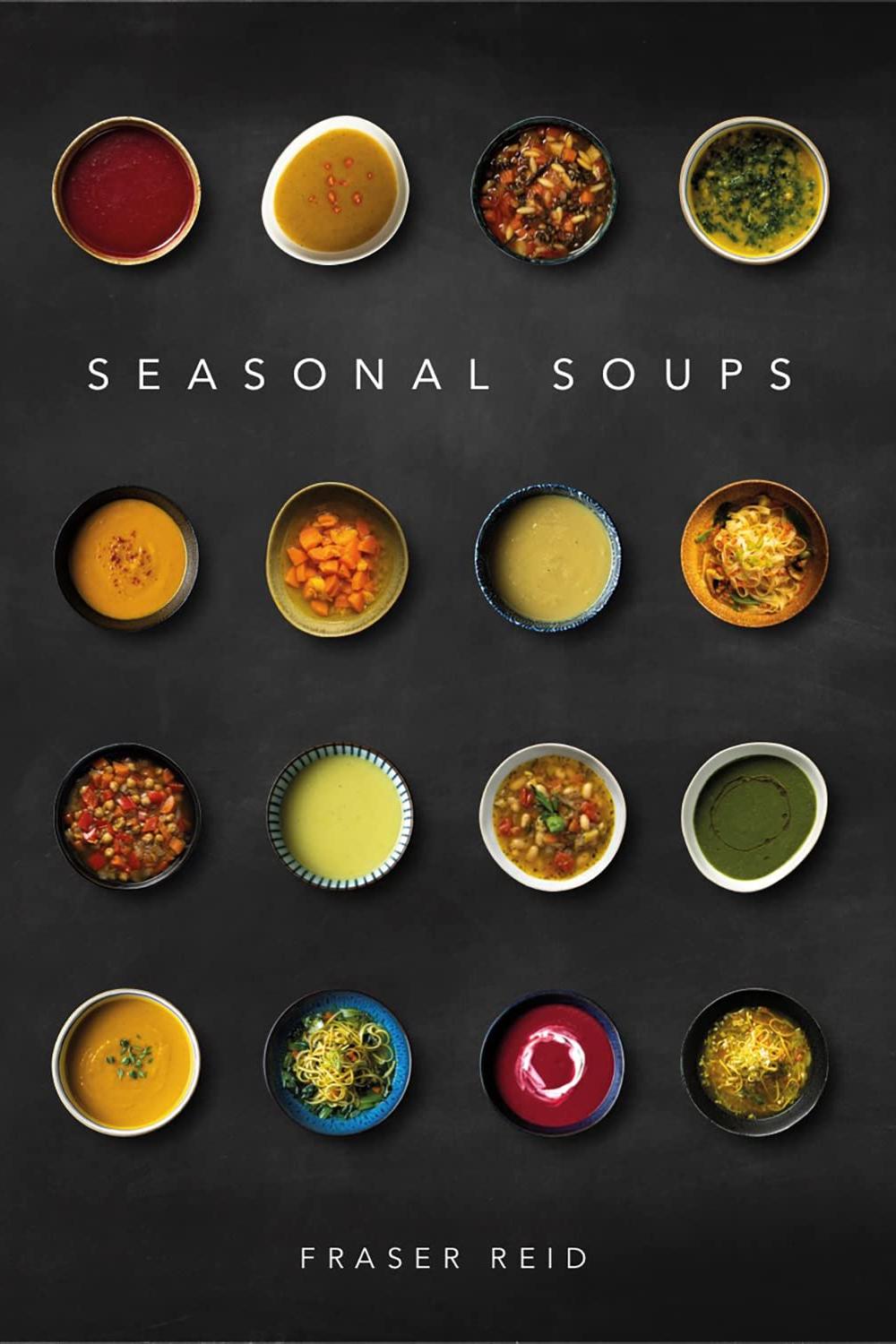Cover of Seasonal Soups cookbook featuring sixteen bowls of different colourful soups on a black background.