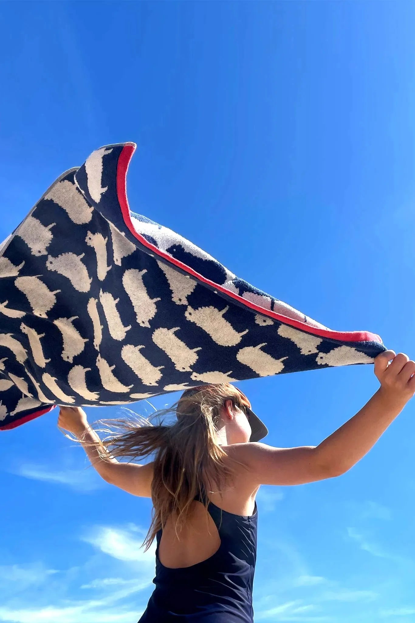 Person holding a patterned organic cotton towel against a blue sky