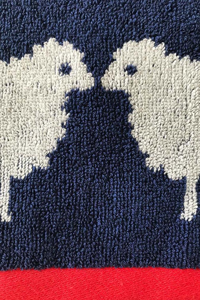 Close-up of a textured fabric with white and navy pattern on a red background