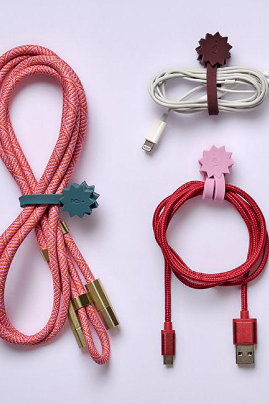 Set of braided cables with colorful clips on a light gray background