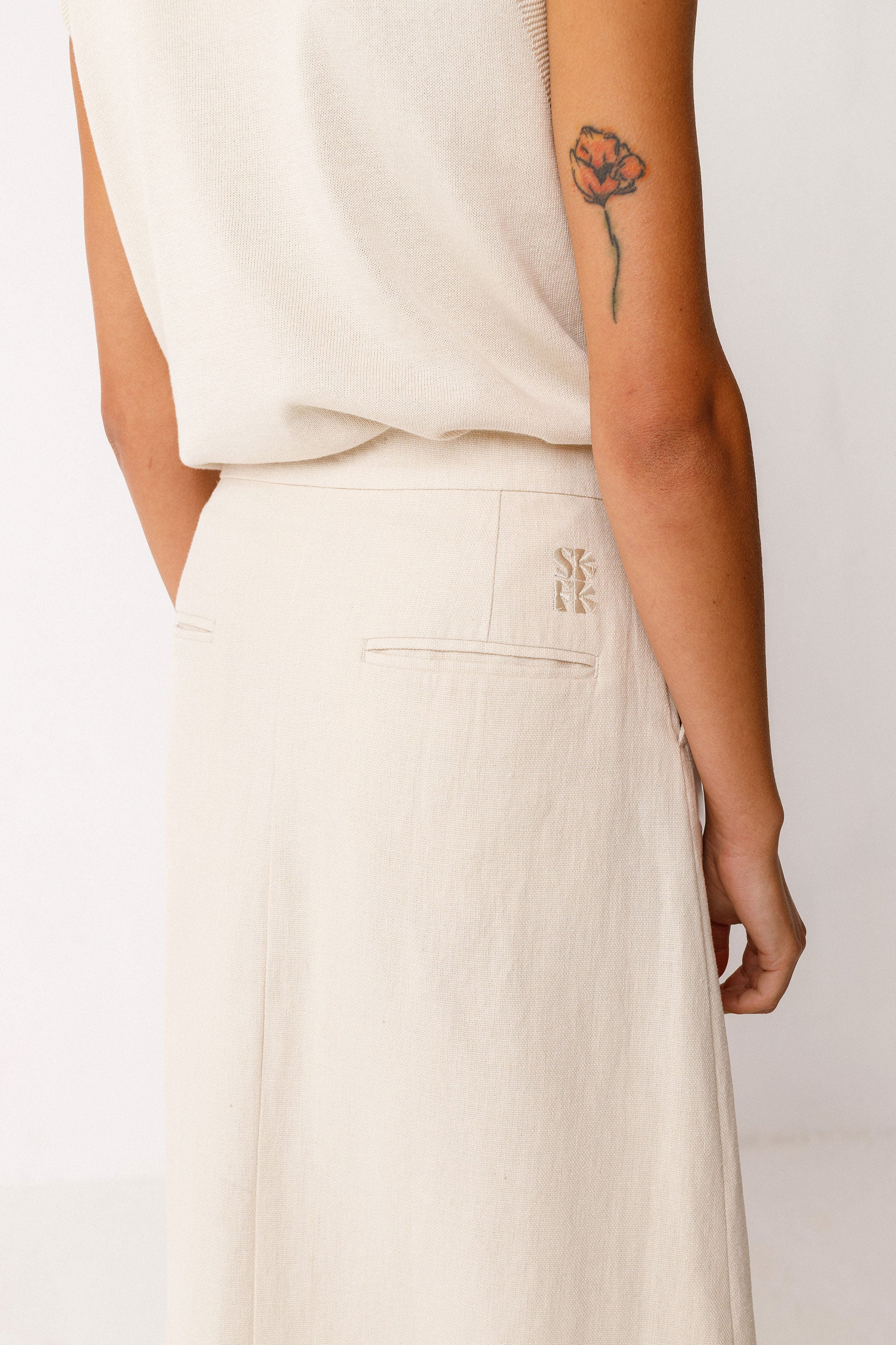 Close up of SKFK logo on ivory linen organic cotton midi skirt