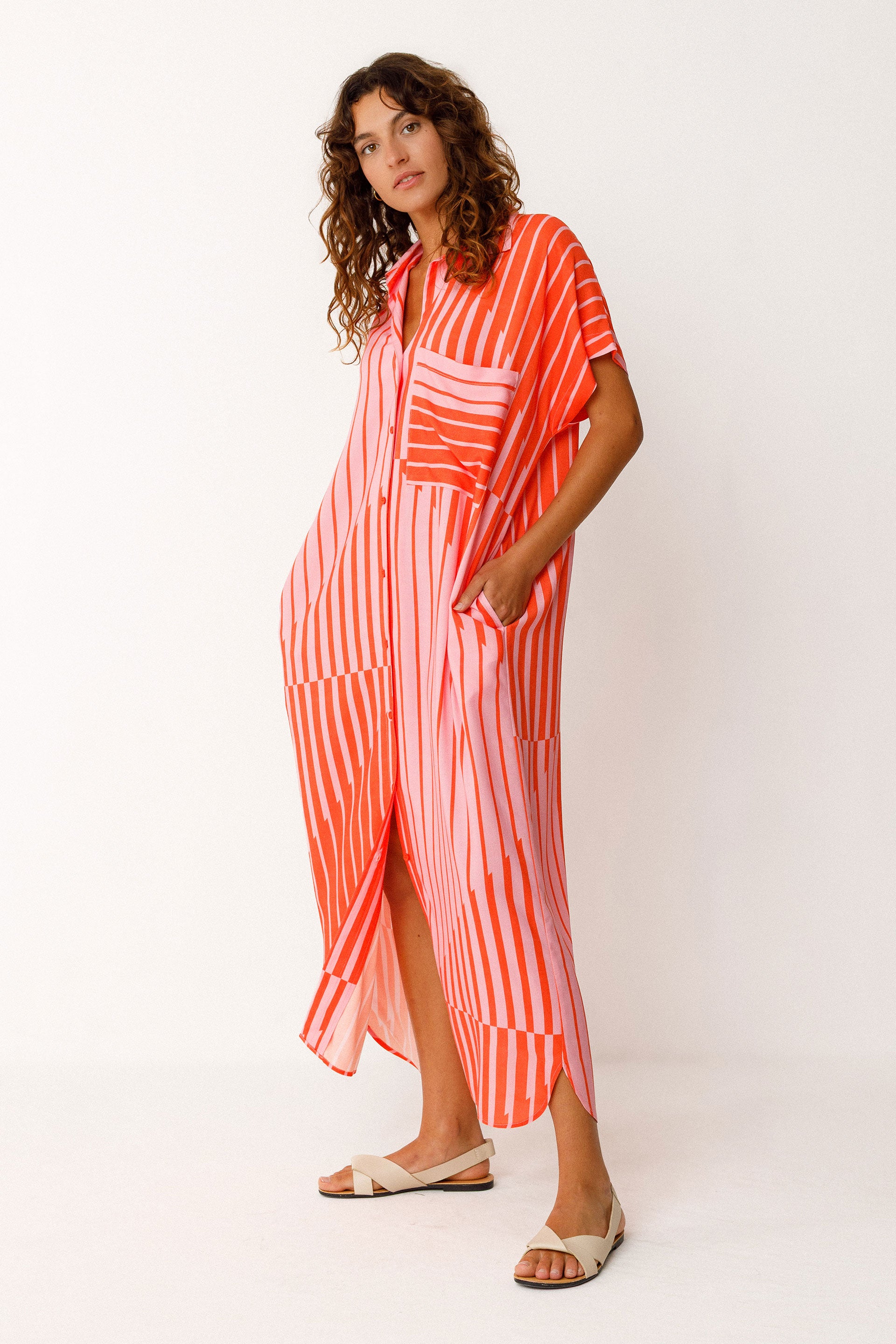 Woman wearing a red and pink striped dress on a white background